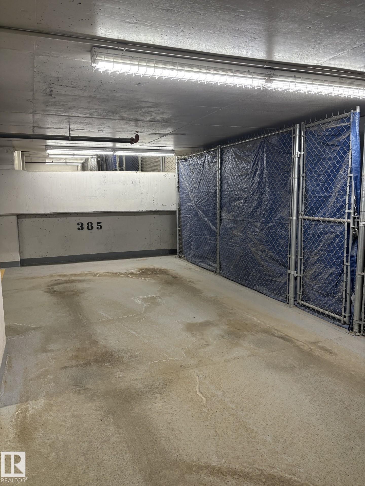 This end unit parking stall features a huge full-length storage cage! - #2804 10238 103 St Nw, Edmonton, AB - Indoor Photo Showing Garage