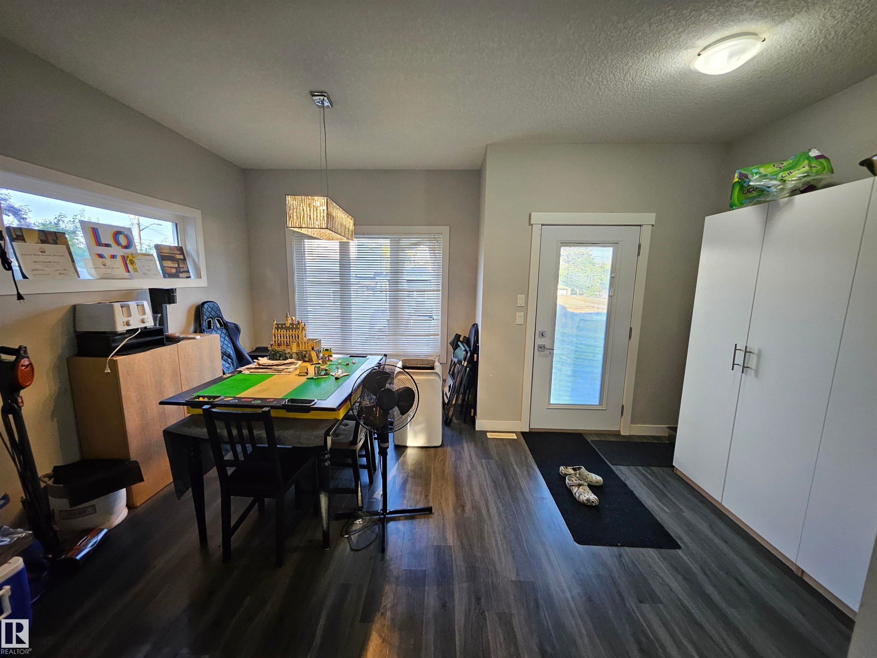 Spacious room featuring wood-finish flooring, light grey walls, and a white ceiling - 13309 104 Street Nw, Edmonton, AB - Indoor Photo Showing Dining Room