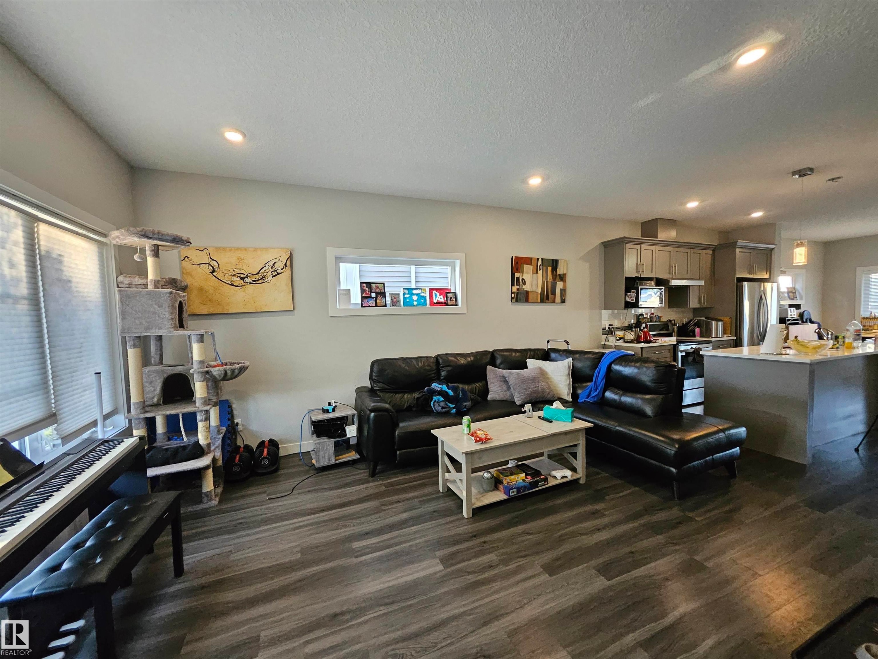Open-concept living area featuring wood-finish flooring, recessed lighting, and large windows - 13309 104 Street Nw, Edmonton, AB - Indoor
