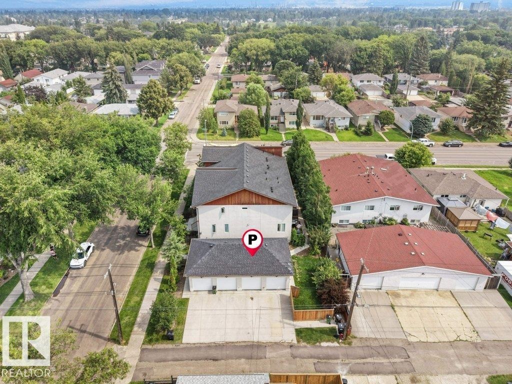 Charming residential property featuring a distinctive two-story design with a dark gray pitched roof, white exterior siding, and wood-finish accents - 7909 105 Avenue Nw, Edmonton, AB - Outdoor With View