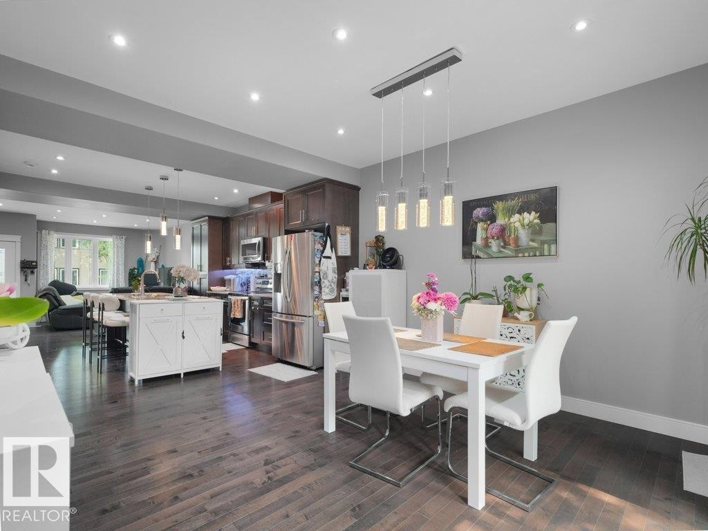 Open-concept living space featuring wood-finish flooring, recessed lighting, and a contemporary dining area with a linear pendant fixture - 7909 105 Avenue Nw, Edmonton, AB - Indoor Photo Showing Dining Room
