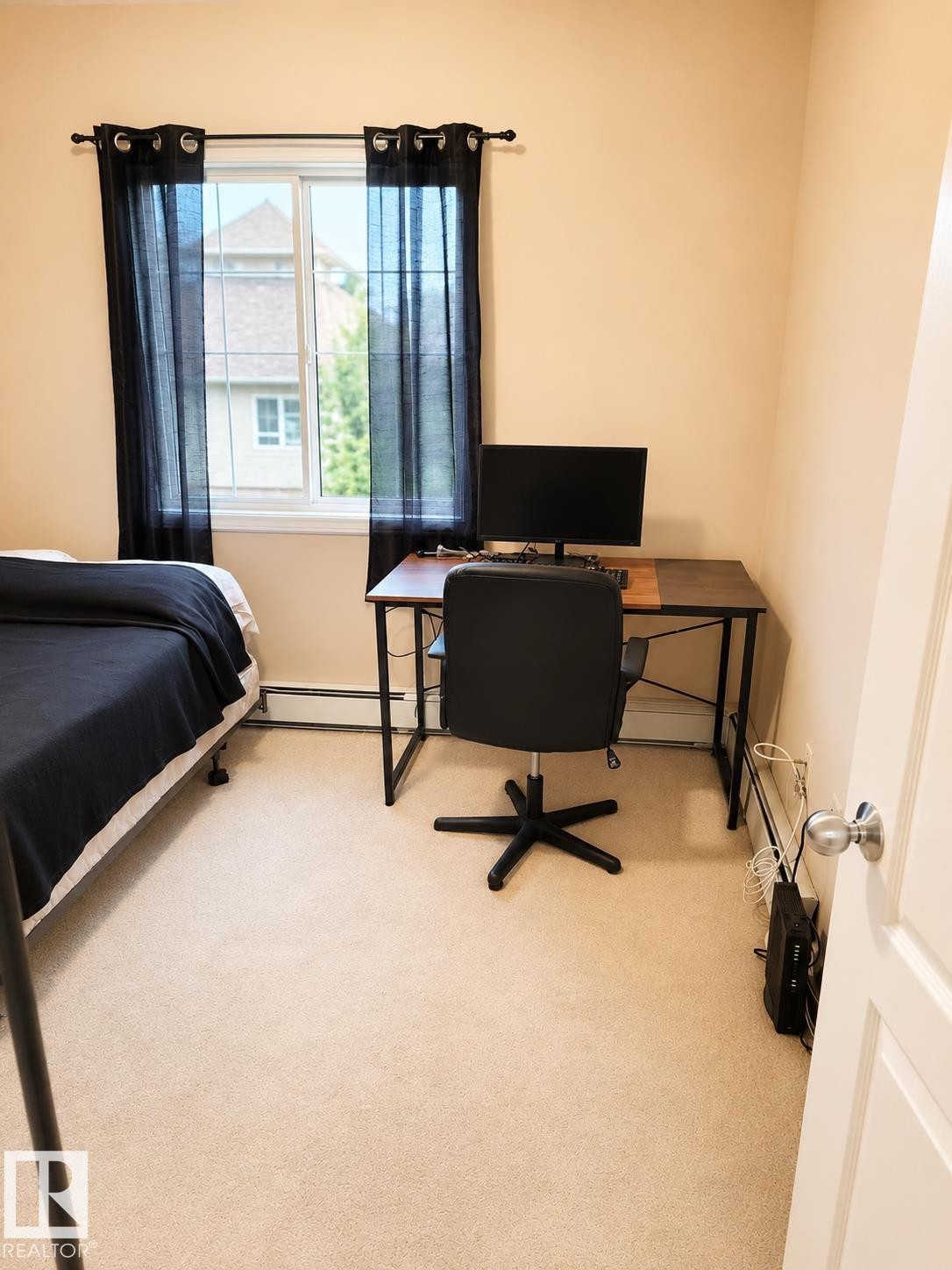 Window-equipped room featuring light neutral wall paint and plush carpeting - #202 16715 100 Av Nw, Edmonton, AB - Indoor