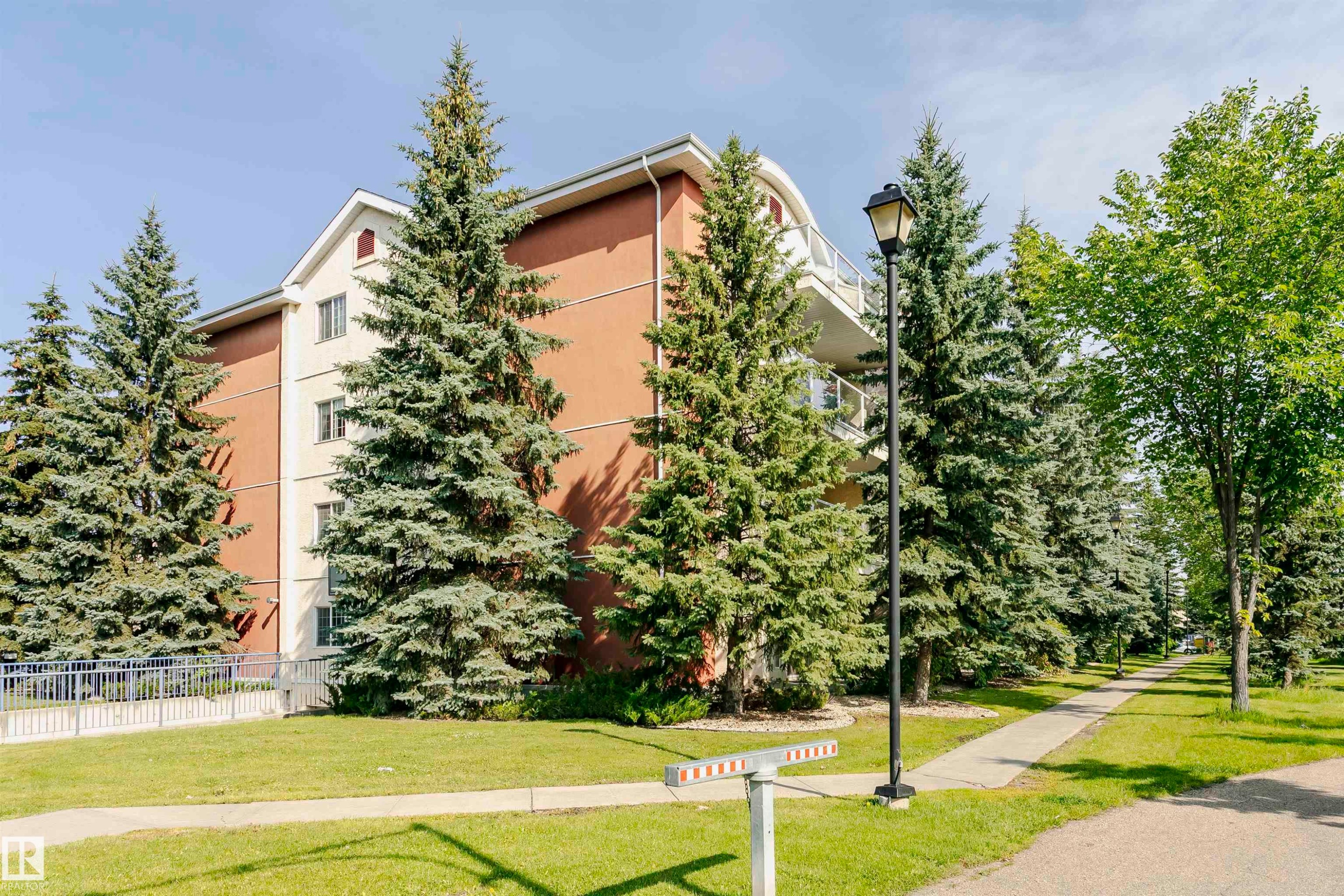 Multi-story building featuring a brown and cream facade, multiple windows, and a curved balcony railing - #106 12110 106 Av Nw, Edmonton, AB - Outdoor