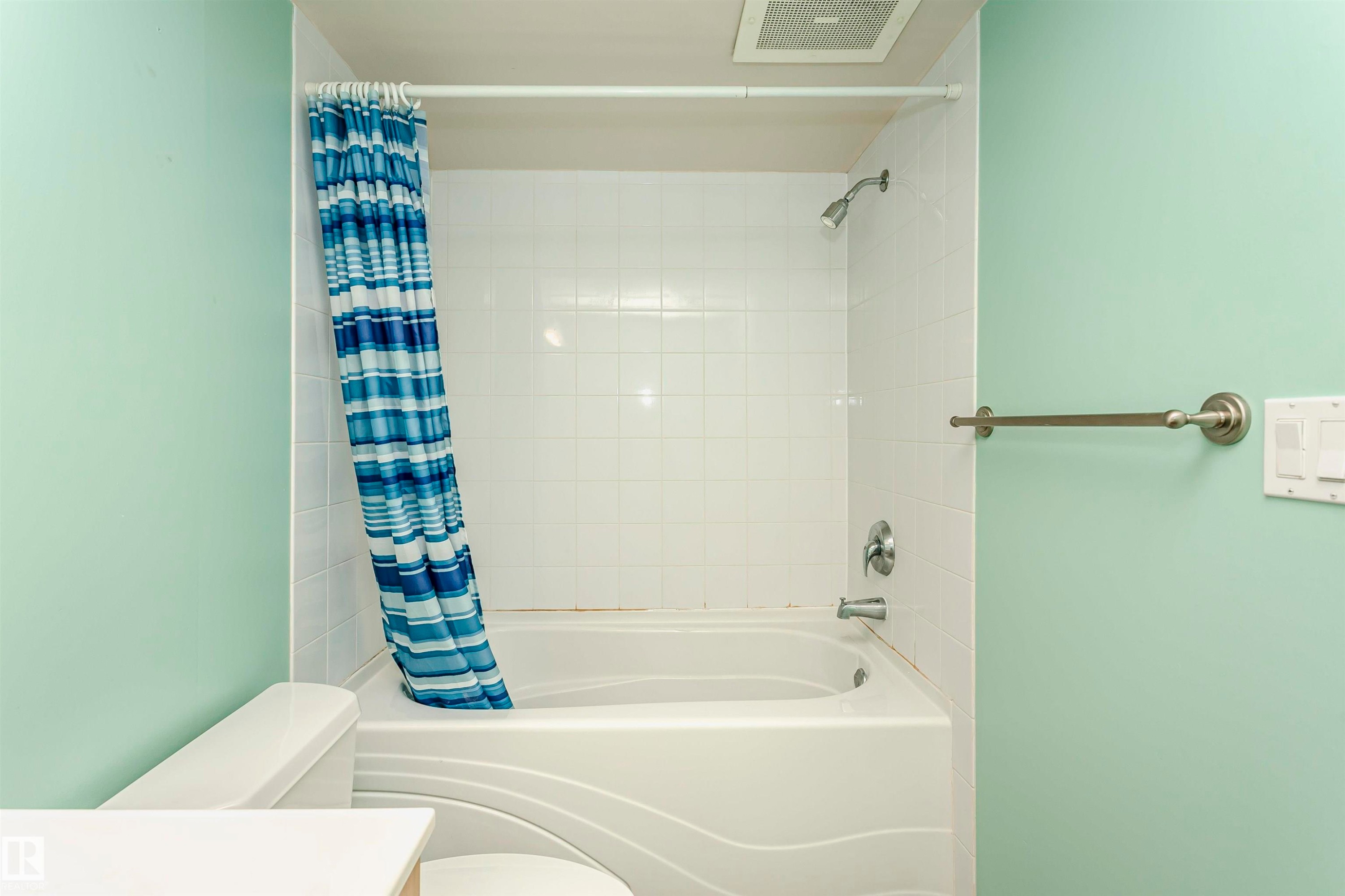 White tiled shower-over-tub with chrome fixtures - #106 12110 106 Av Nw, Edmonton, AB - Indoor Photo Showing Bathroom