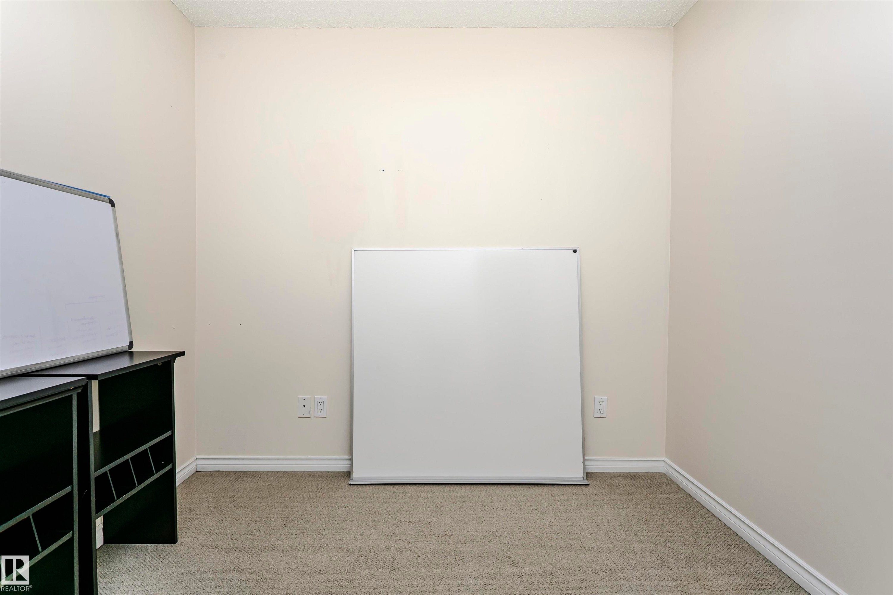 Carpeted room with neutral wall paint and white baseboards - #106 12110 106 Av Nw, Edmonton, AB - Indoor Photo Showing Other Room