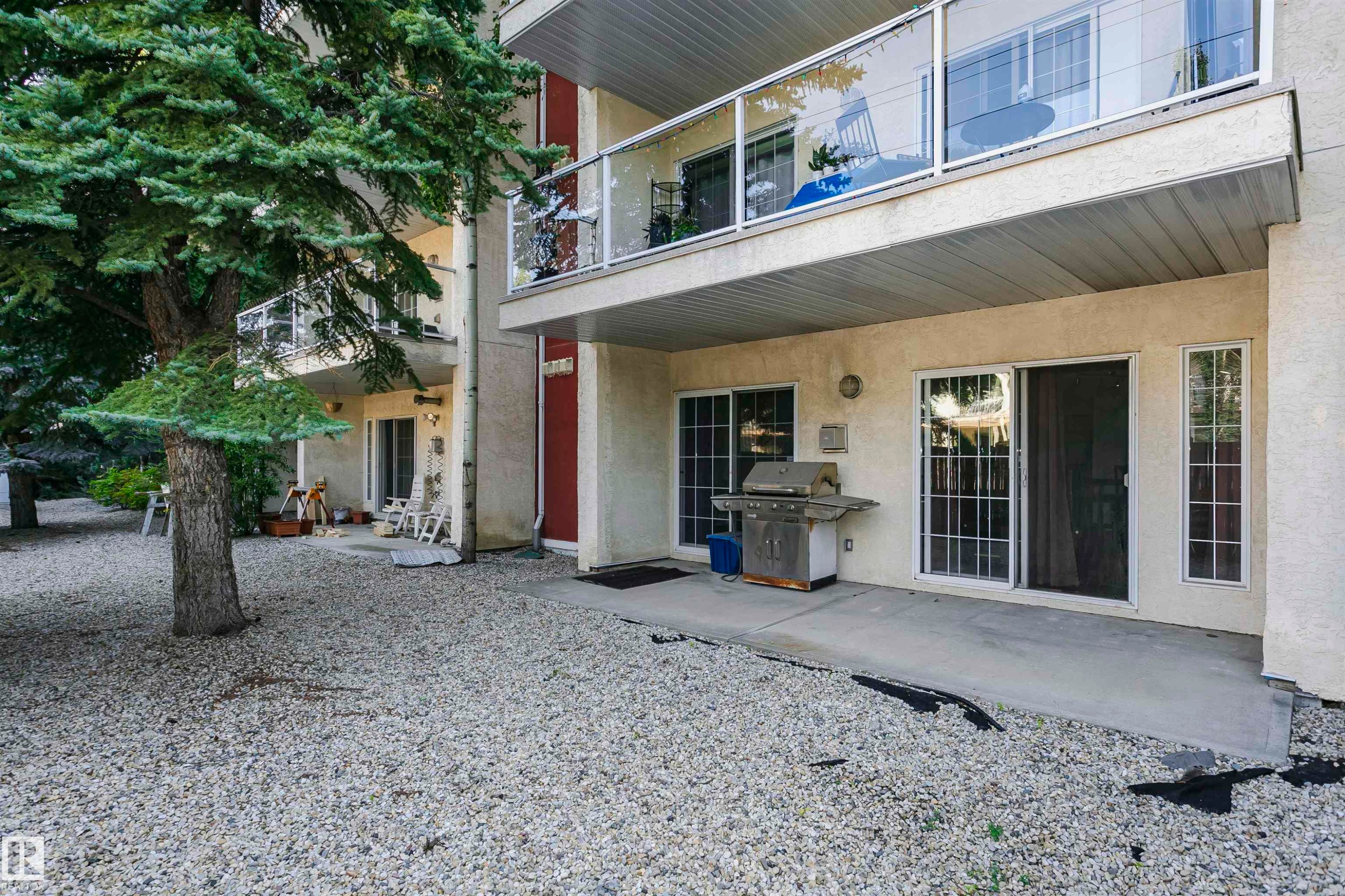 Ground-floor patio with a concrete surface and gravel landscaping - #106 12110 106 Av Nw, Edmonton, AB - Outdoor