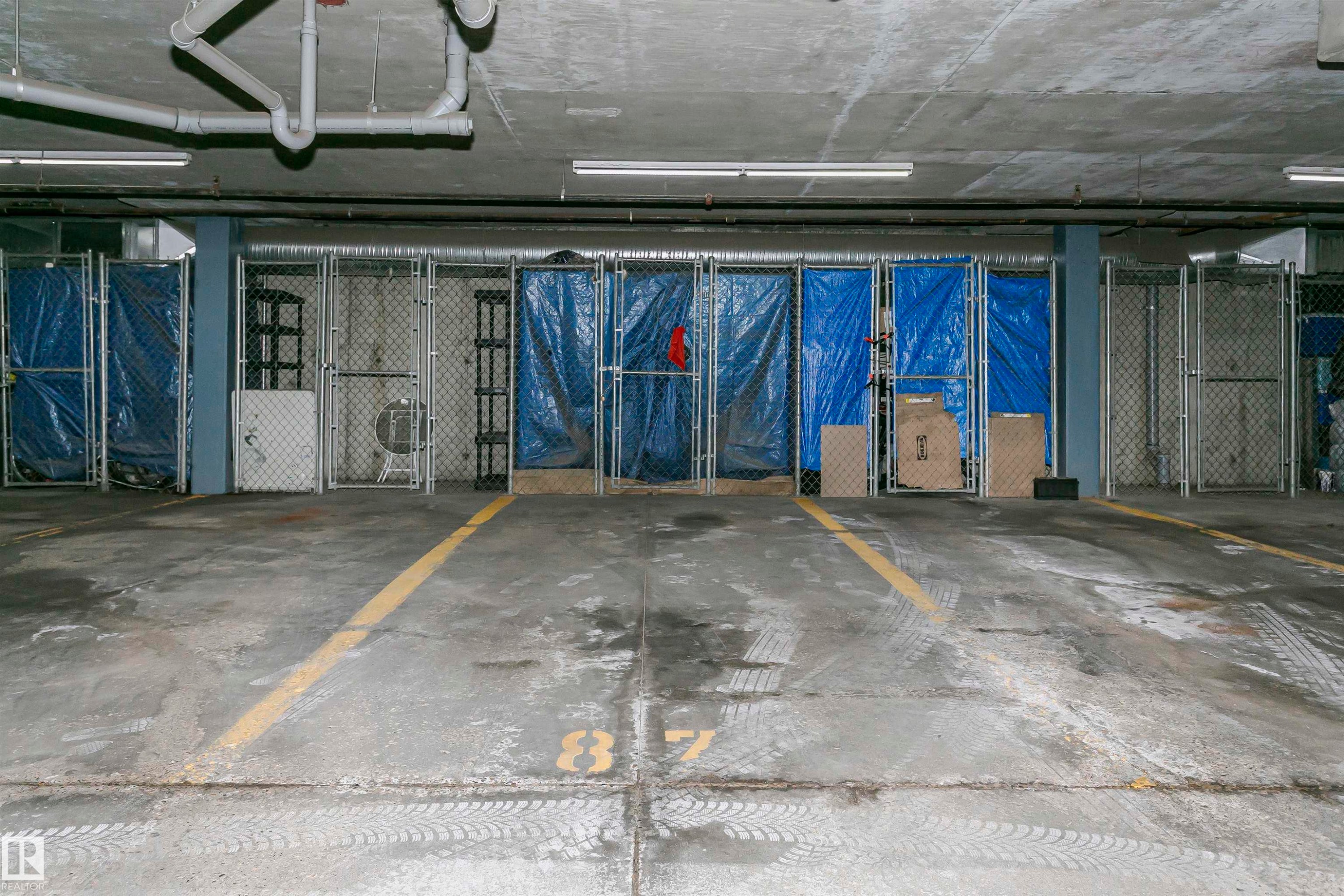 Concrete flooring with painted yellow lines - #106 12110 106 Av Nw, Edmonton, AB - Indoor Photo Showing Garage