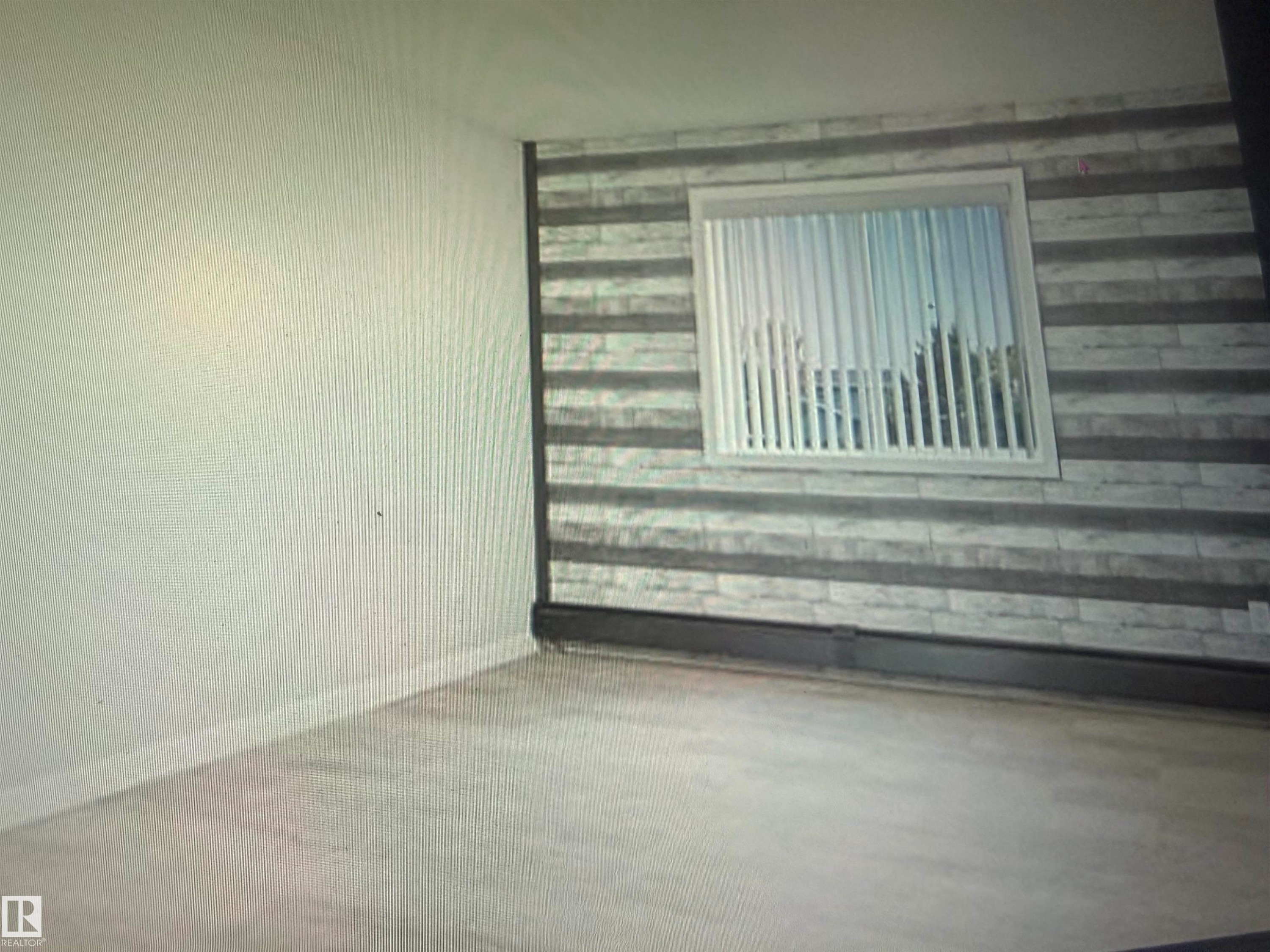 Light wood-finish flooring with crisp white baseboards - #106 592 Hooke Rd Nw, Edmonton, AB - Indoor Photo Showing Other Room