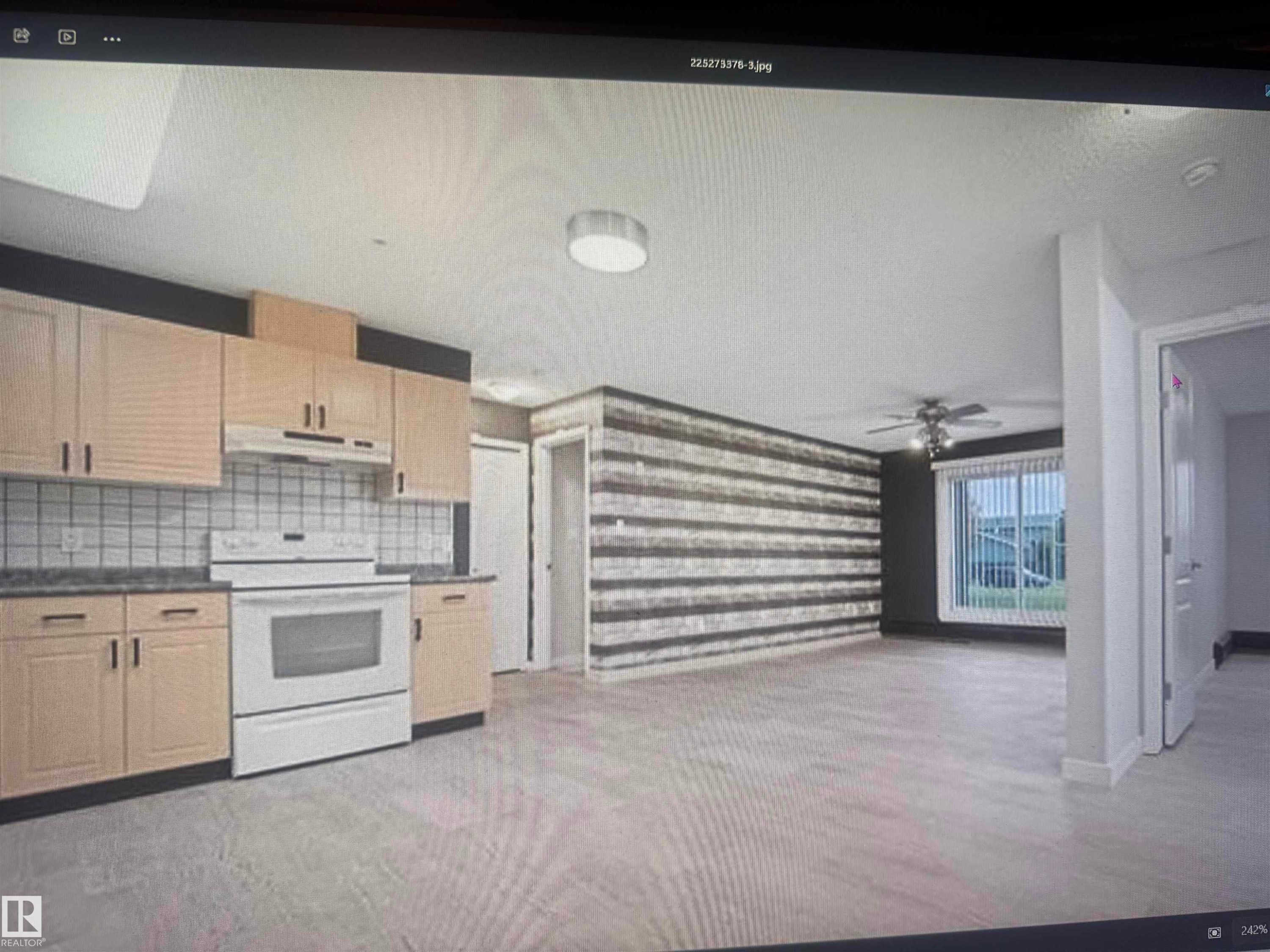 Open-concept living space featuring wood-finish flooring throughout, a kitchen with light-toned cabinetry and white tile backsplash, a white electric range, and a ceiling fan with integrated lighting - #106 592 Hooke Rd Nw, Edmonton, AB - Indoor Photo Showing Kitchen
