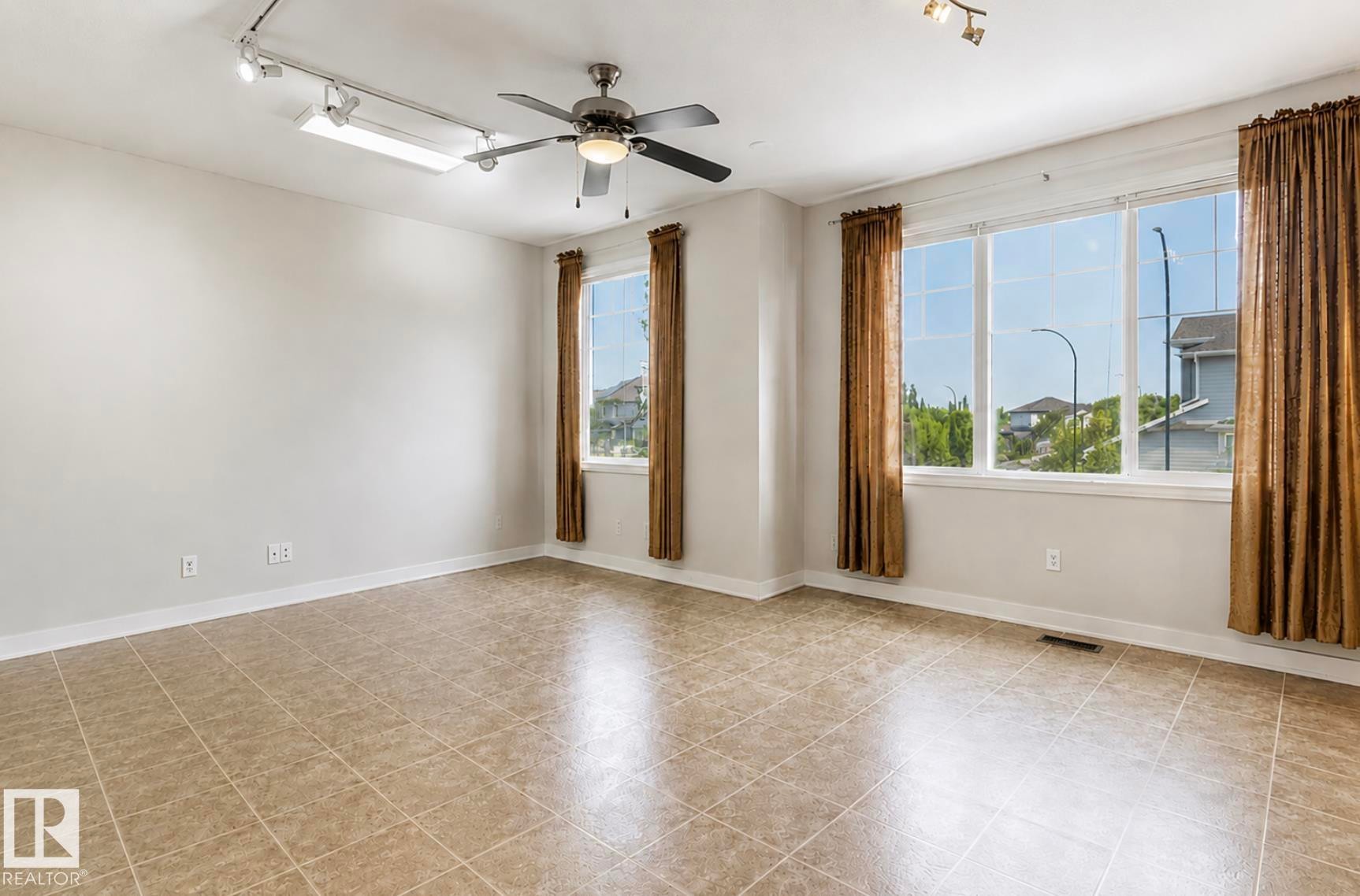 Spacious room featuring neutral wall tones, large windows, and tile flooring - 22 Voleta Crest, Spruce Grove, AB - Indoor Photo Showing Other Room