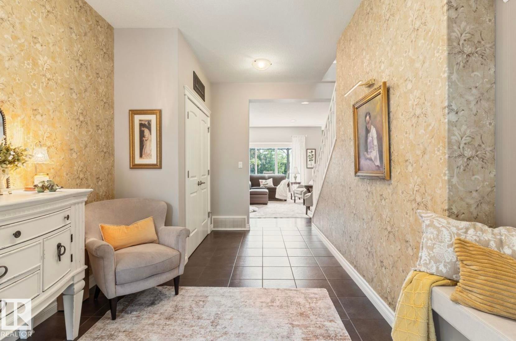 Elegant hallway showcasing neutral wallcovering with subtle pattern detail, dark wood-finish flooring, and recessed ceiling lighting - 22 Voleta Crest, Spruce Grove, AB - Indoor Photo Showing Other Room