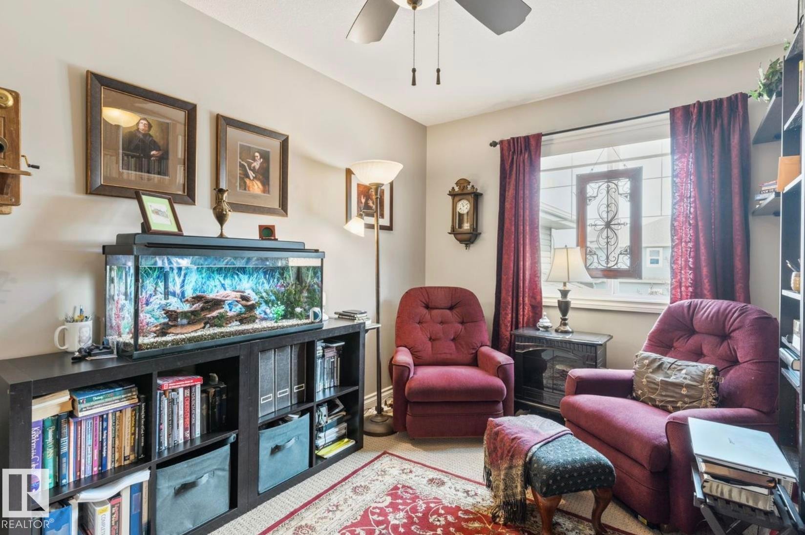 Warmly appointed room featuring a ceiling fan, a window with decorative leaded glass, and built-in shelving - 22 Voleta Crest, Spruce Grove, AB - Indoor