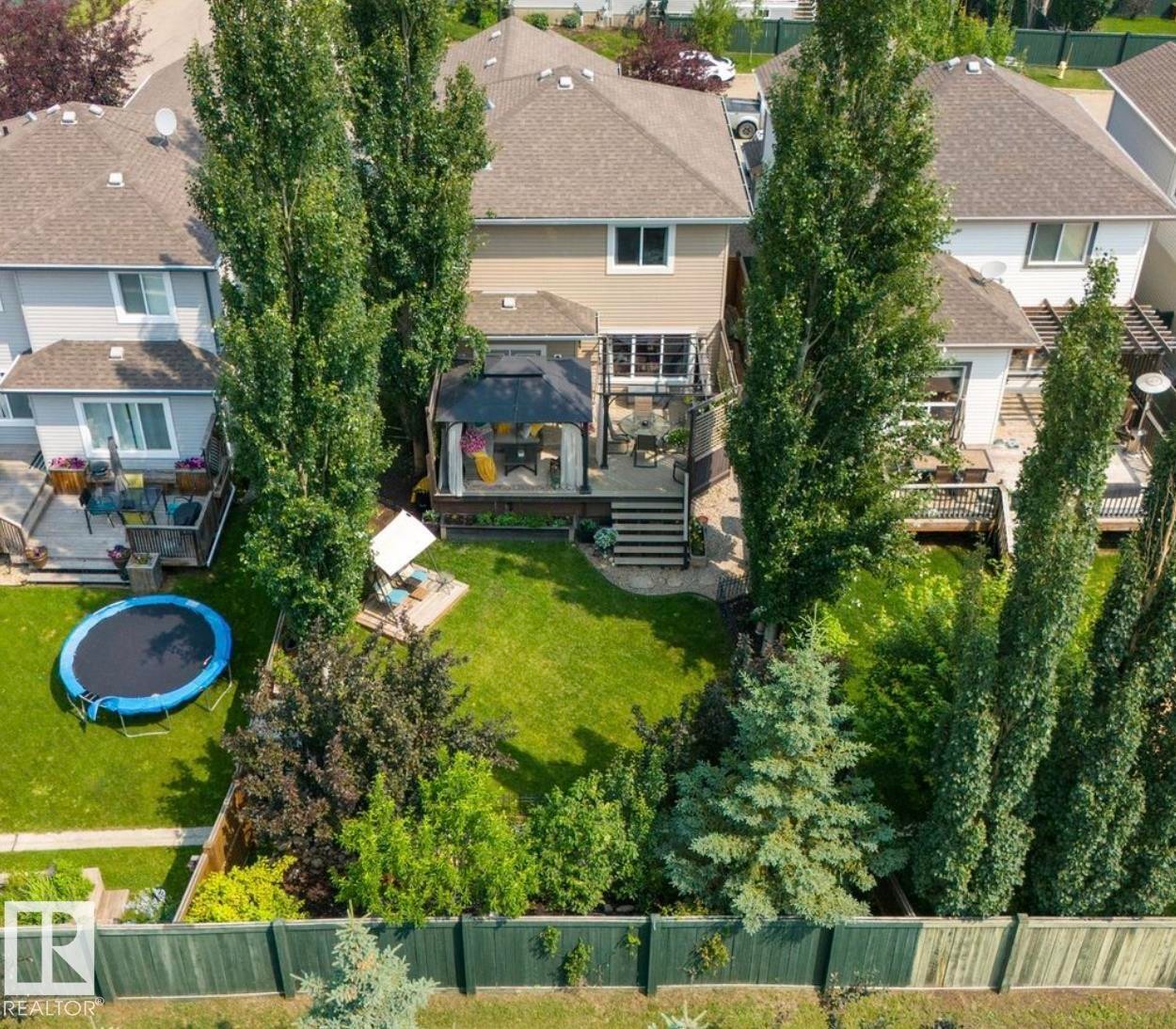 Expansive backyard featuring a multi-tiered deck, built-in gazebo, and mature trees providing natural privacy - 22 Voleta Crest, Spruce Grove, AB - Outdoor With Deck Patio Veranda