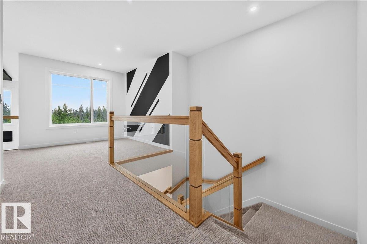 Modern staircase featuring wood balusters and glass panels - 403 172 Avenue Nw, Edmonton, AB - Indoor Photo Showing Other Room