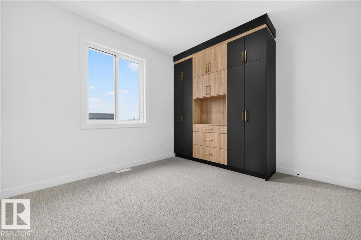 Built-in storage system featuring matte black and wood-finish cabinetry with gold-tone hardware - 403 172 Avenue Nw, Edmonton, AB - Indoor Photo Showing Other Room