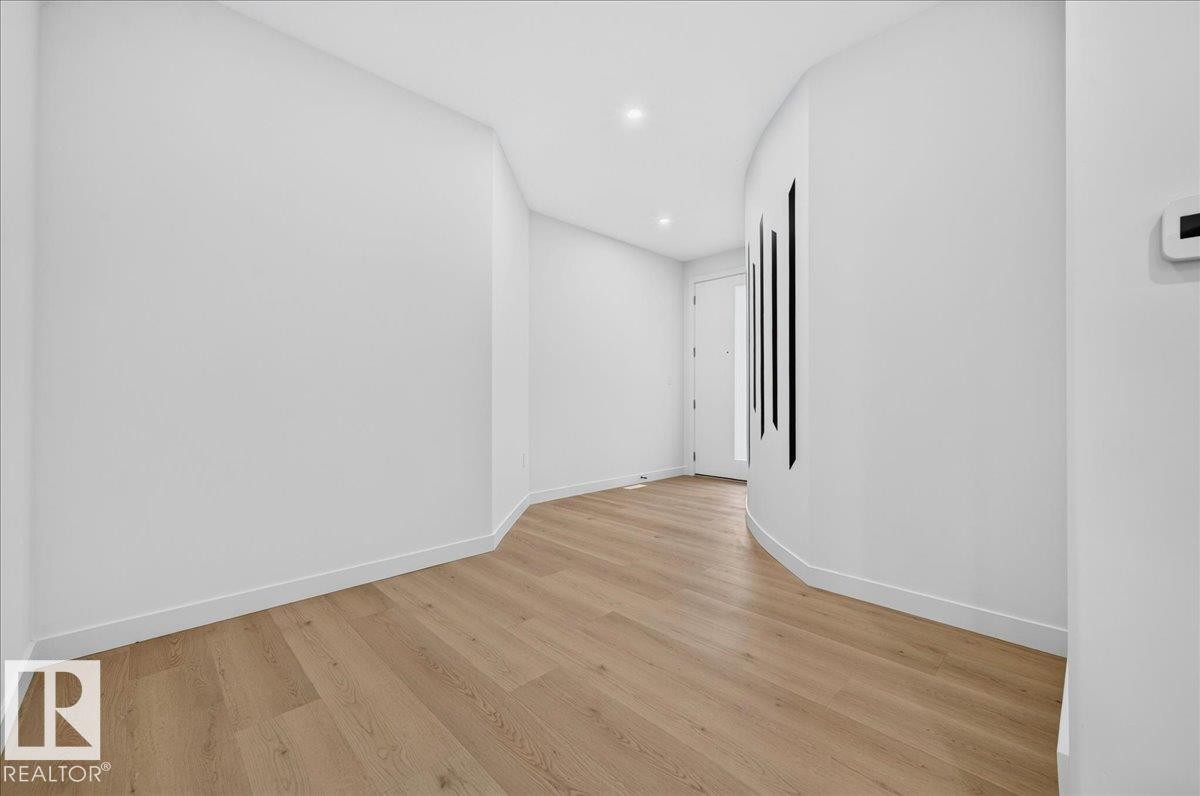 Entryway featuring wood-finish flooring, recessed lighting, and a white entrance door with vertical glass inserts - 403 172 Avenue Nw, Edmonton, AB - Indoor Photo Showing Other Room