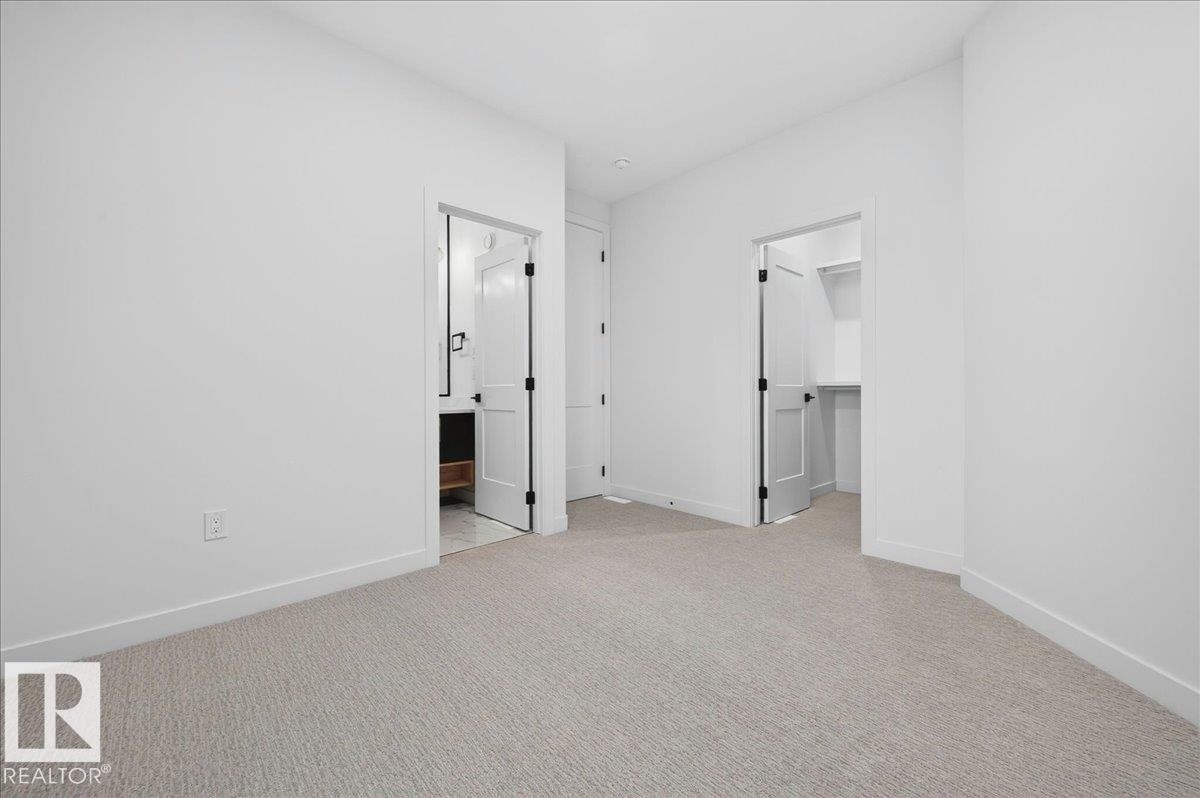 Carpeted room with white walls, featuring white trim and baseboards - 403 172 Avenue Nw, Edmonton, AB - Indoor Photo Showing Other Room