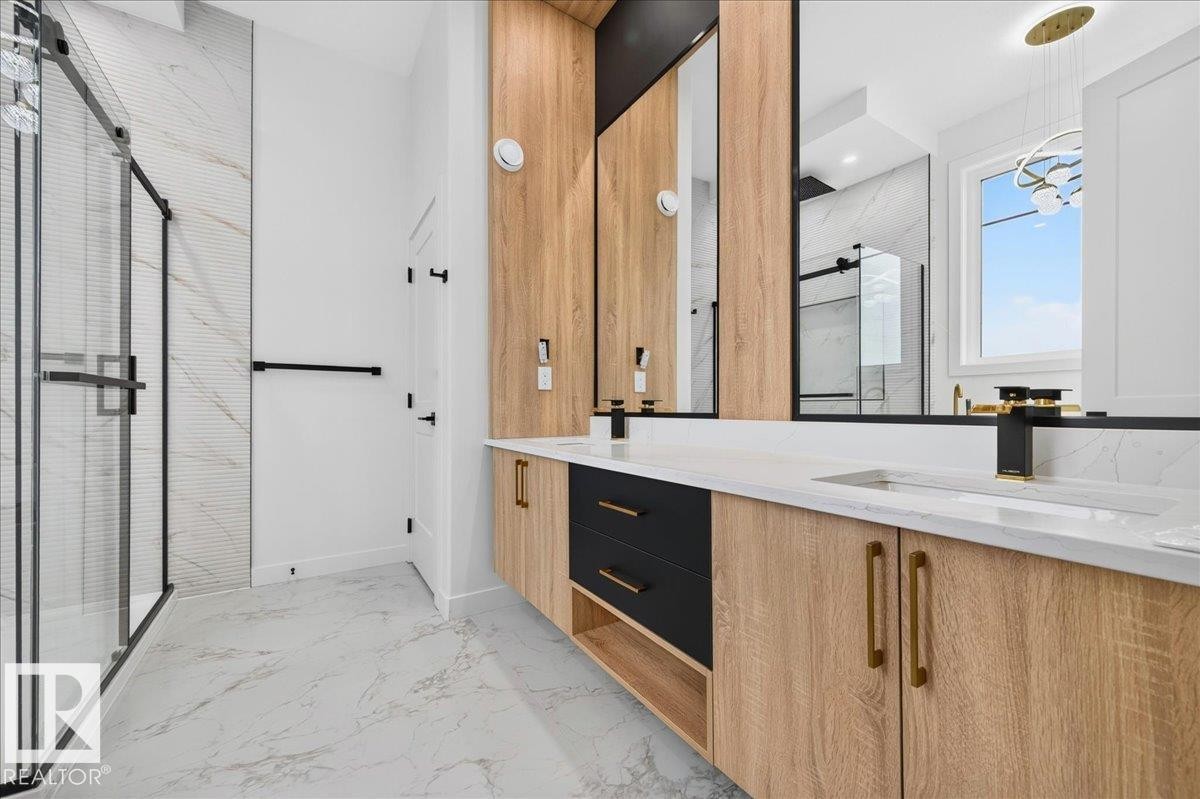 Dual vanity with integrated sinks, white countertops, and black and brass fixtures - 403 172 Avenue Nw, Edmonton, AB - Indoor