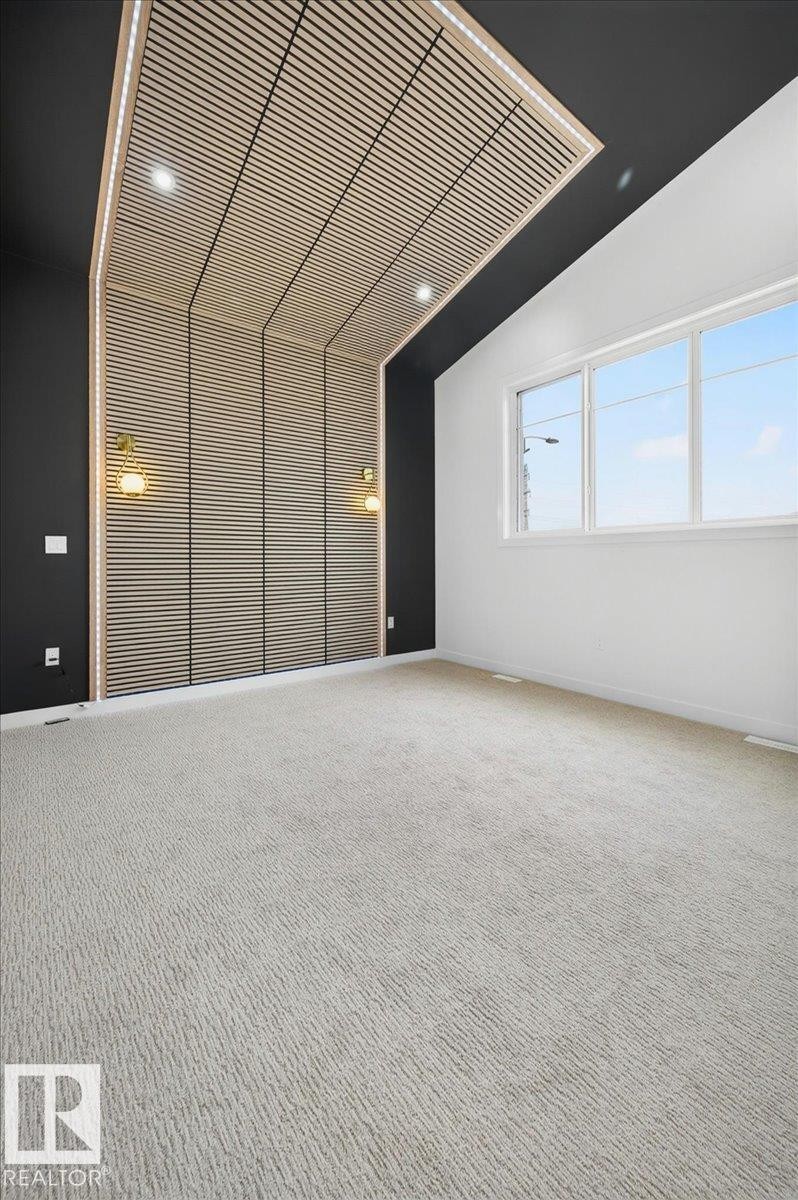 Room featuring a decorative slatted wood accent wall and ceiling with integrated recessed lighting - 403 172 Avenue Nw, Edmonton, AB - Indoor Photo Showing Other Room