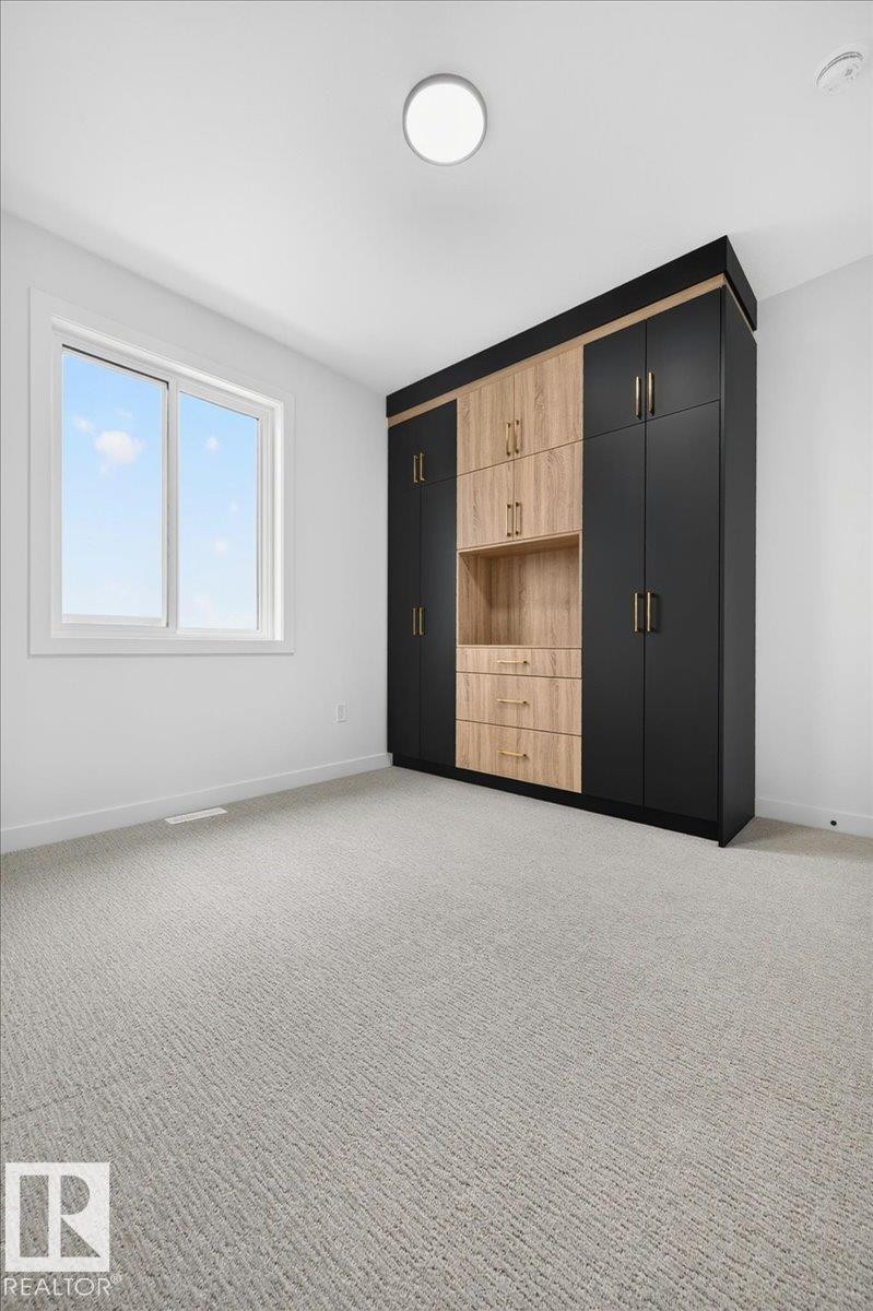 Built-in wardrobe system featuring black and wood-finish cabinetry with gold-tone hardware - 403 172 Avenue Nw, Edmonton, AB - Indoor Photo Showing Other Room