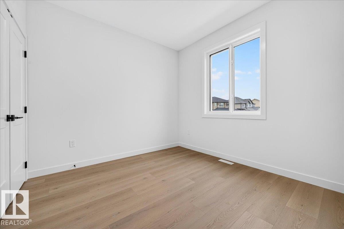 Room featuring light wood-finish flooring, white walls, and a white trim package - 403 172 Avenue Nw, Edmonton, AB - Indoor Photo Showing Other Room