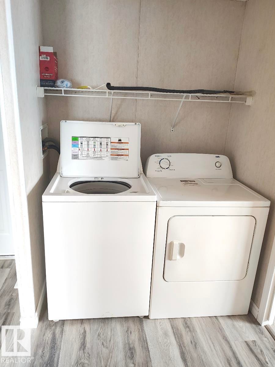 Dedicated laundry area with wood-finish flooring - 4819 51 Avenue, Millet, AB - Indoor Photo Showing Laundry Room