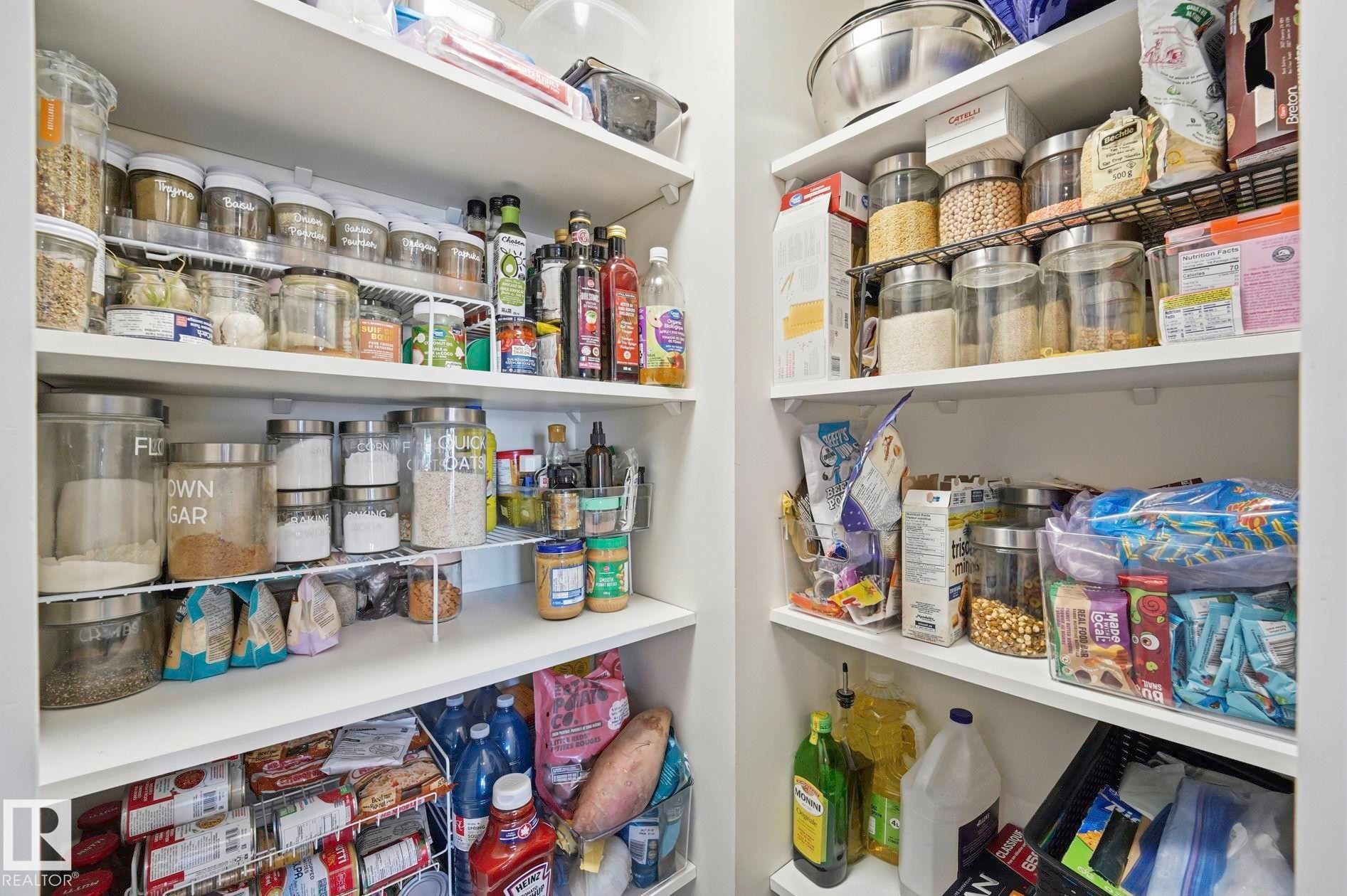 Built-in pantry with multiple white shelving units and wire racks, offering organized storage - 215 85 Street Sw, Edmonton, AB - Indoor With Storage