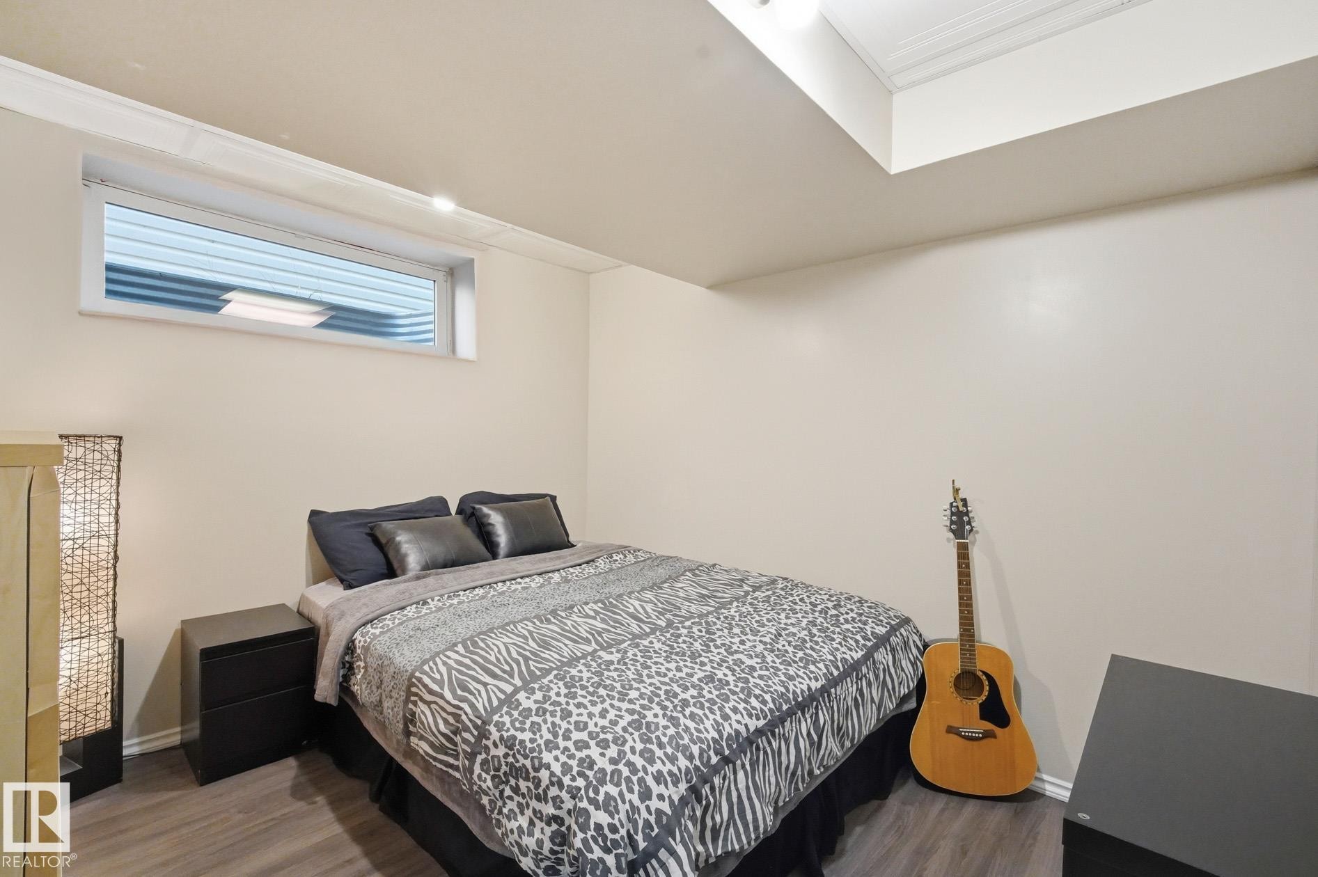 Recessed window with white trim, crown molding, and wood-finish flooring - 215 85 Street Sw, Edmonton, AB - Indoor Photo Showing Bedroom
