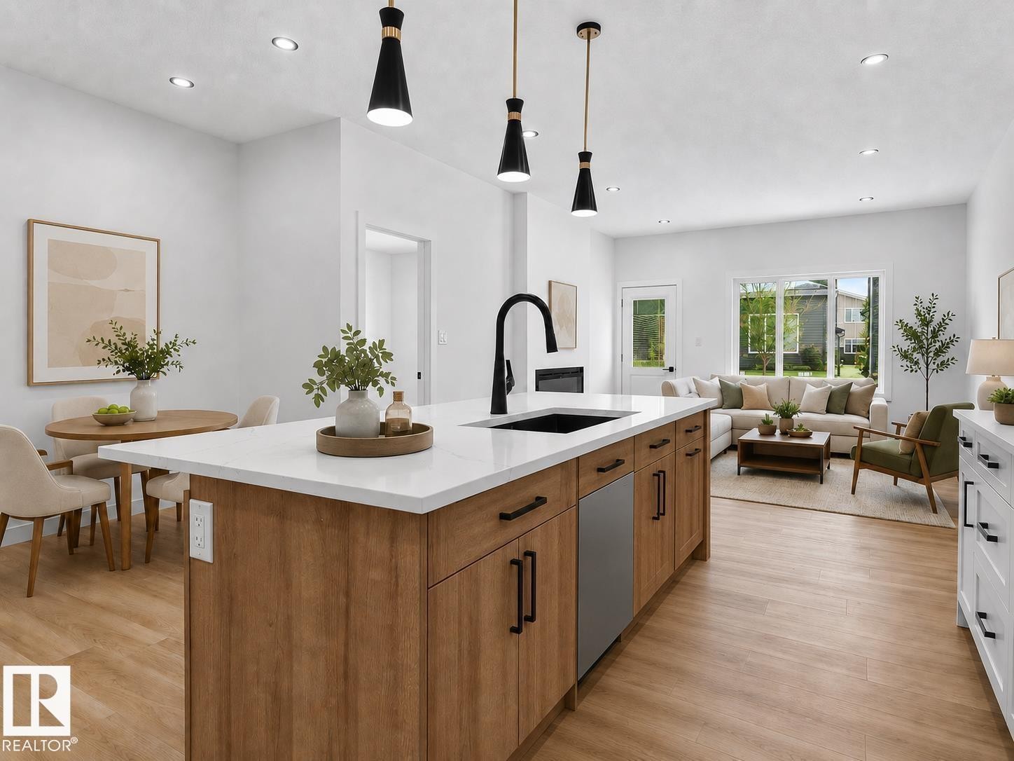 Spacious kitchen island featuring a white countertop, undermount sink with a black matte faucet, and wood-finish cabinetry - 3318 Chickadee Drive Nw, Edmonton, AB - Indoor Photo Showing Kitchen With Upgraded Kitchen