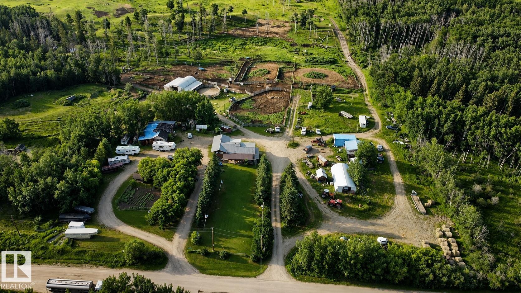 Extensive property featuring multiple outbuildings, fenced enclosures, and substantial wooded acreage - 11218 Twp Rd 590, Rural St. Paul County, AB - Outdoor With View