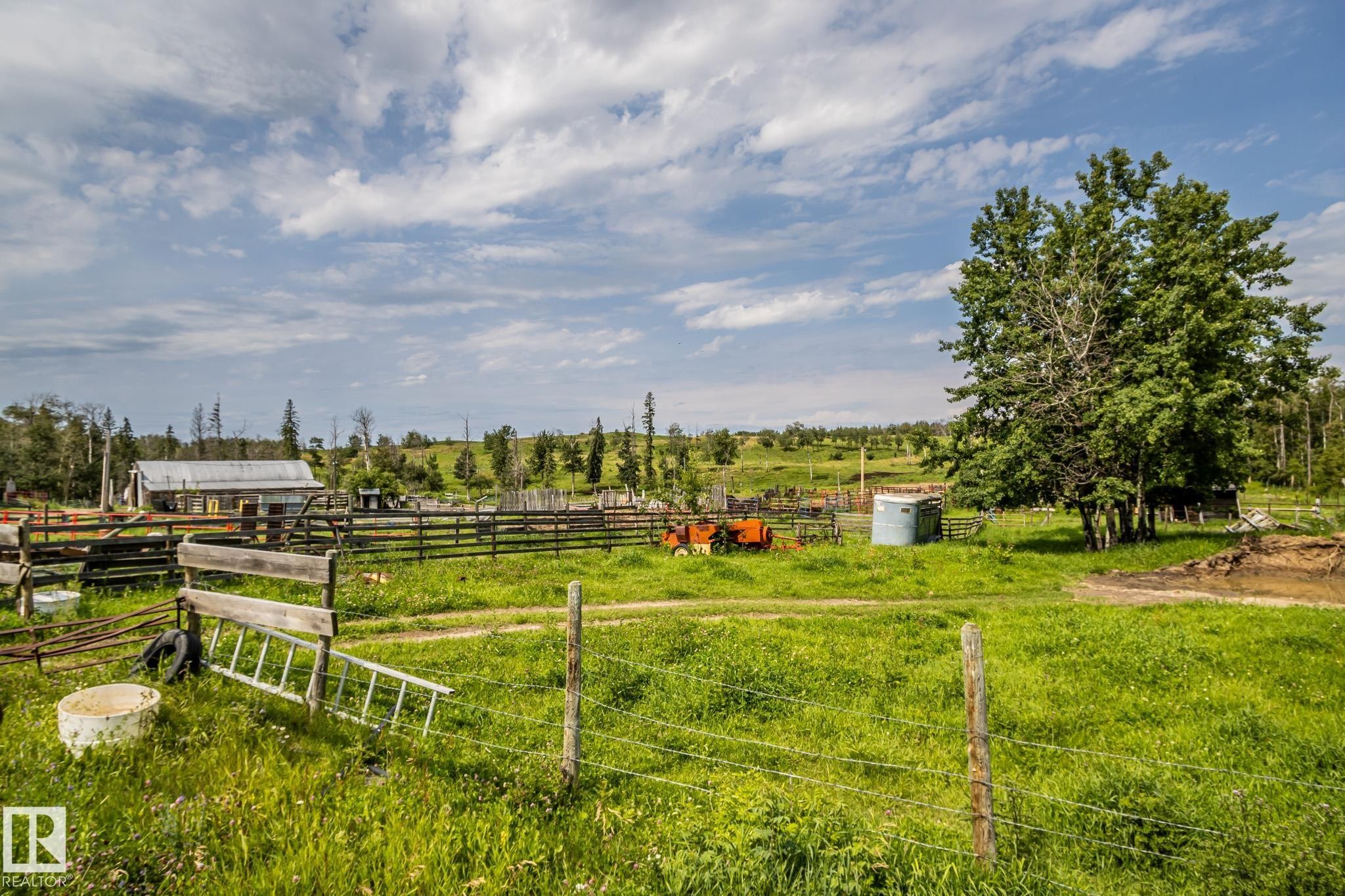 Expansive rural property featuring a large field, mature trees, and a distant outbuilding - 11218 Twp Rd 590, Rural St. Paul County, AB - Outdoor With View