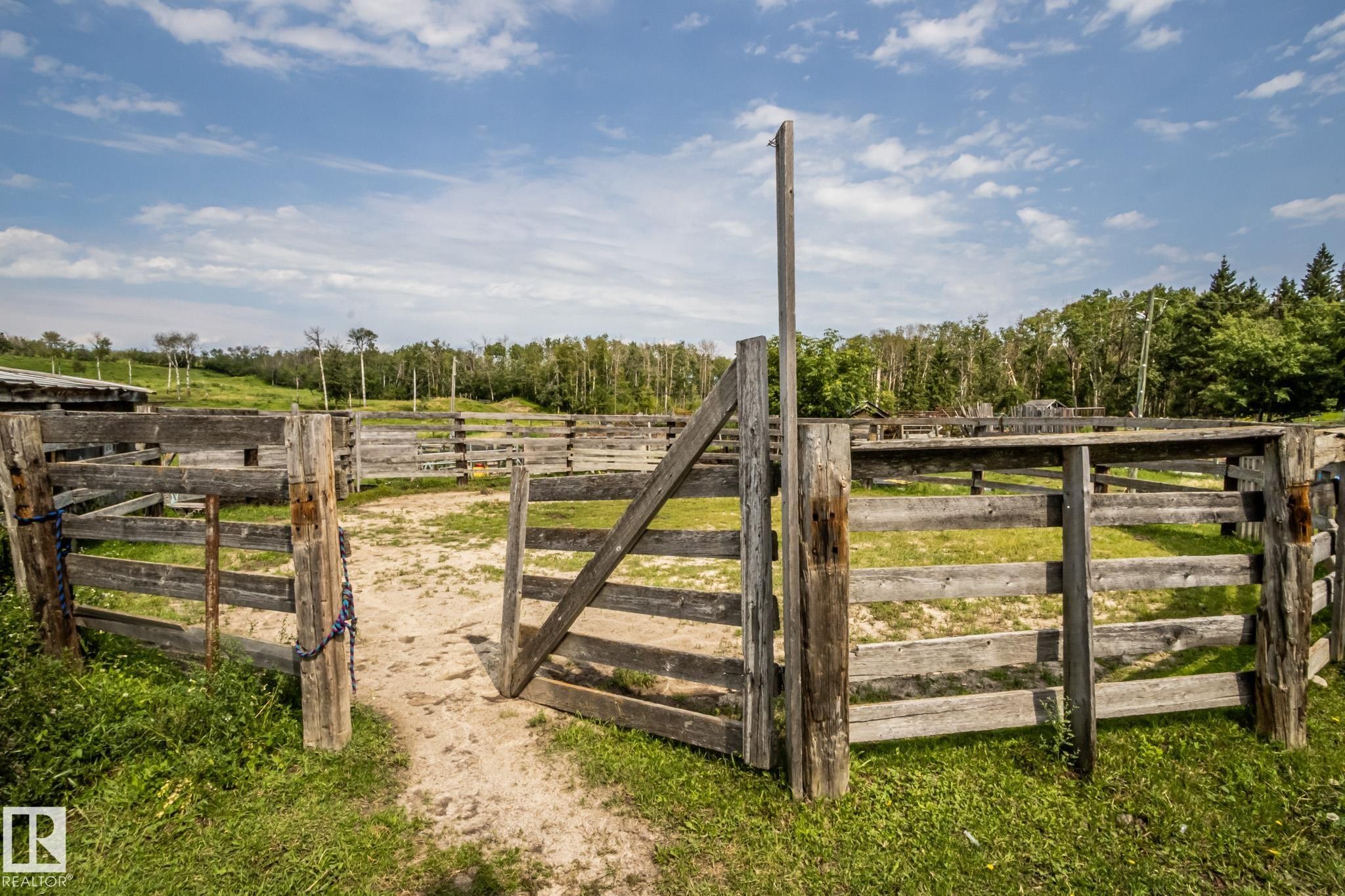 Expansive outdoor pen system featuring wood fencing and an open gate - 11218 Twp Rd 590, Rural St. Paul County, AB - Outdoor With View
