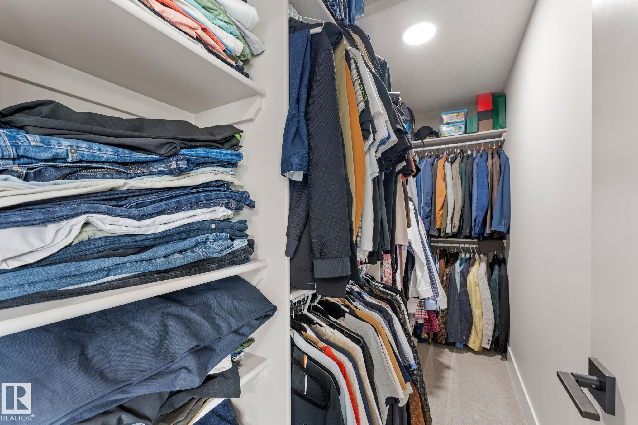 Walk-in closet featuring extensive built-in shelving, multiple hanging rods, recessed lighting, and soft gray carpeting - 12383 176 Avenue Nw, Edmonton, AB - Indoor Photo Showing Bedroom