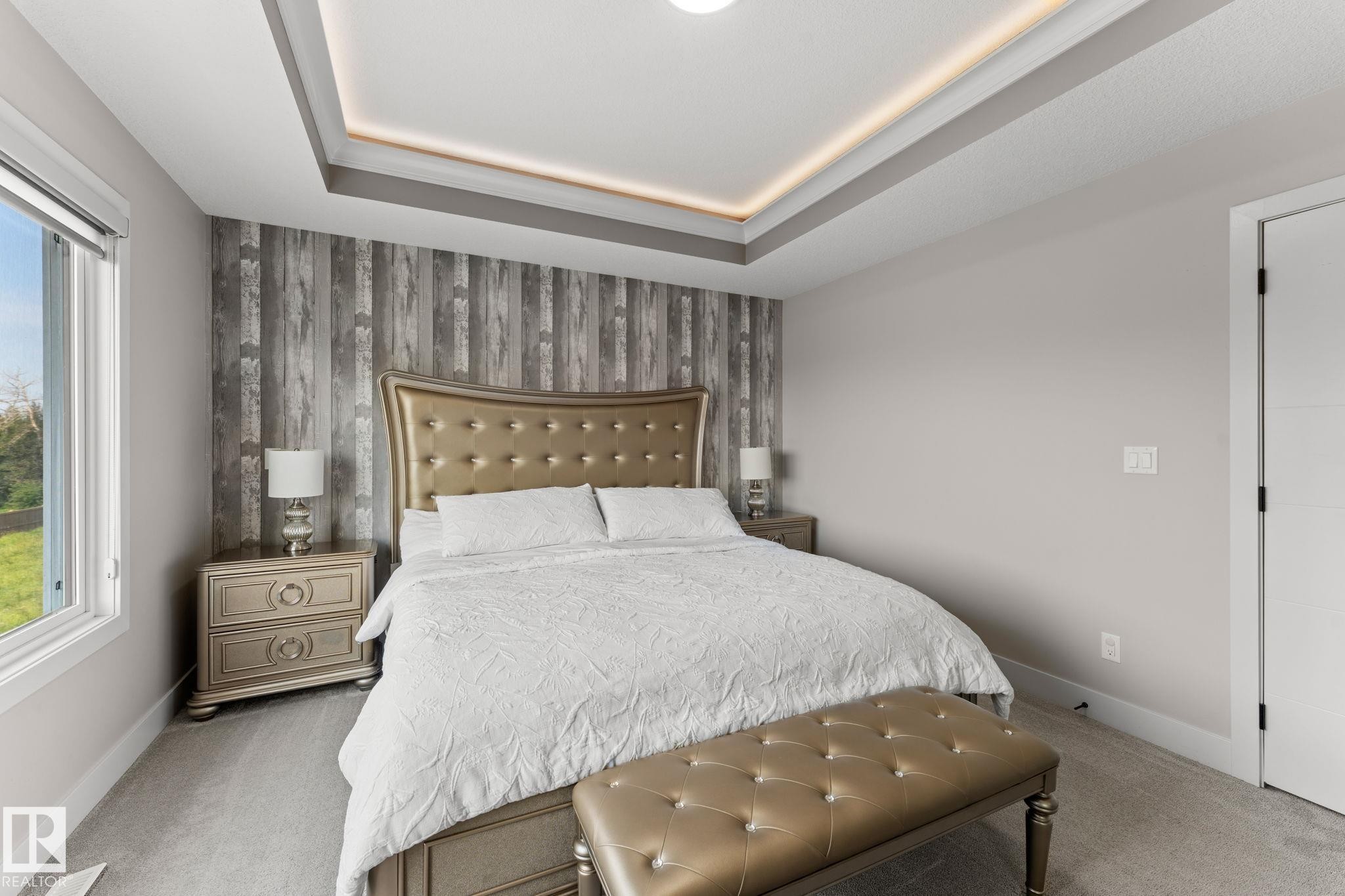 Tray ceiling with recessed lighting above a feature wall with wood-finish paneling - 12383 176 Avenue Nw, Edmonton, AB - Indoor Photo Showing Bedroom