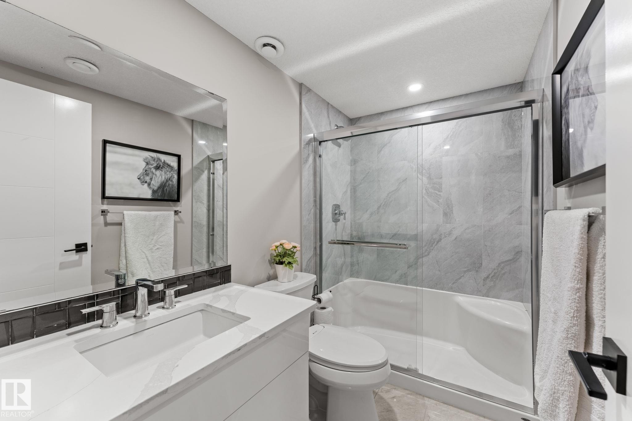 Bathroom featuring a white vanity with an integrated rectangular sink and polished chrome faucet, dark subway tile backsplash, and a large mirror - 12383 176 Avenue Nw, Edmonton, AB - Outdoor With Deck Patio Veranda