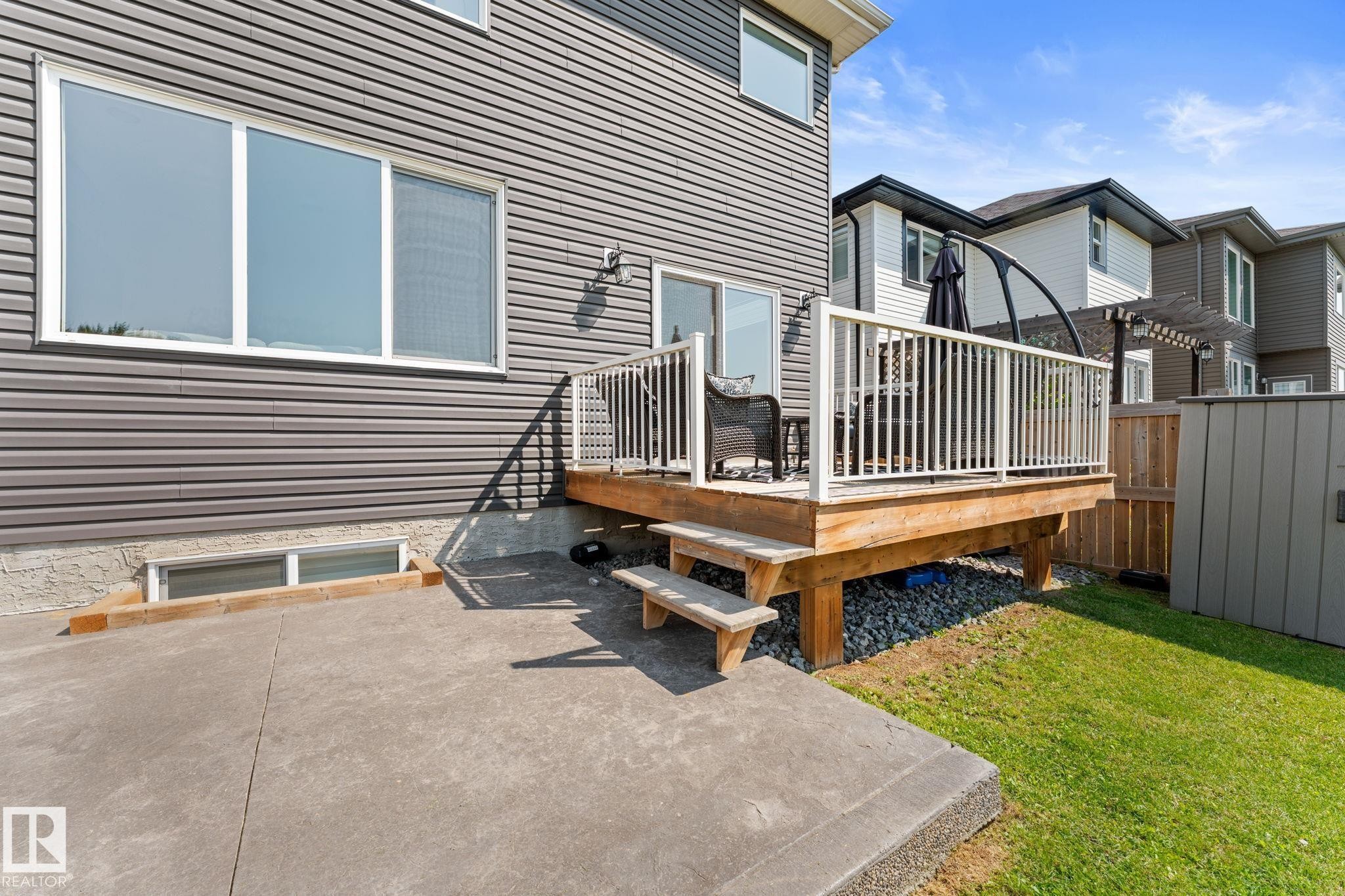 Elevated wood deck with white railing, accessed via sliding glass doors - 12383 176 Avenue Nw, Edmonton, AB - Outdoor With Deck Patio Veranda With Exterior