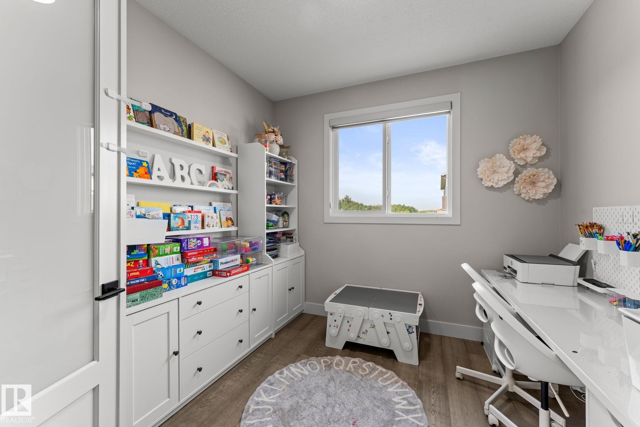 Room featuring built-in white cabinetry with varied storage options, a window, light gray wall paint, and wood-finish flooring - 12383 176 Avenue Nw, Edmonton, AB - Indoor Photo Showing Bathroom