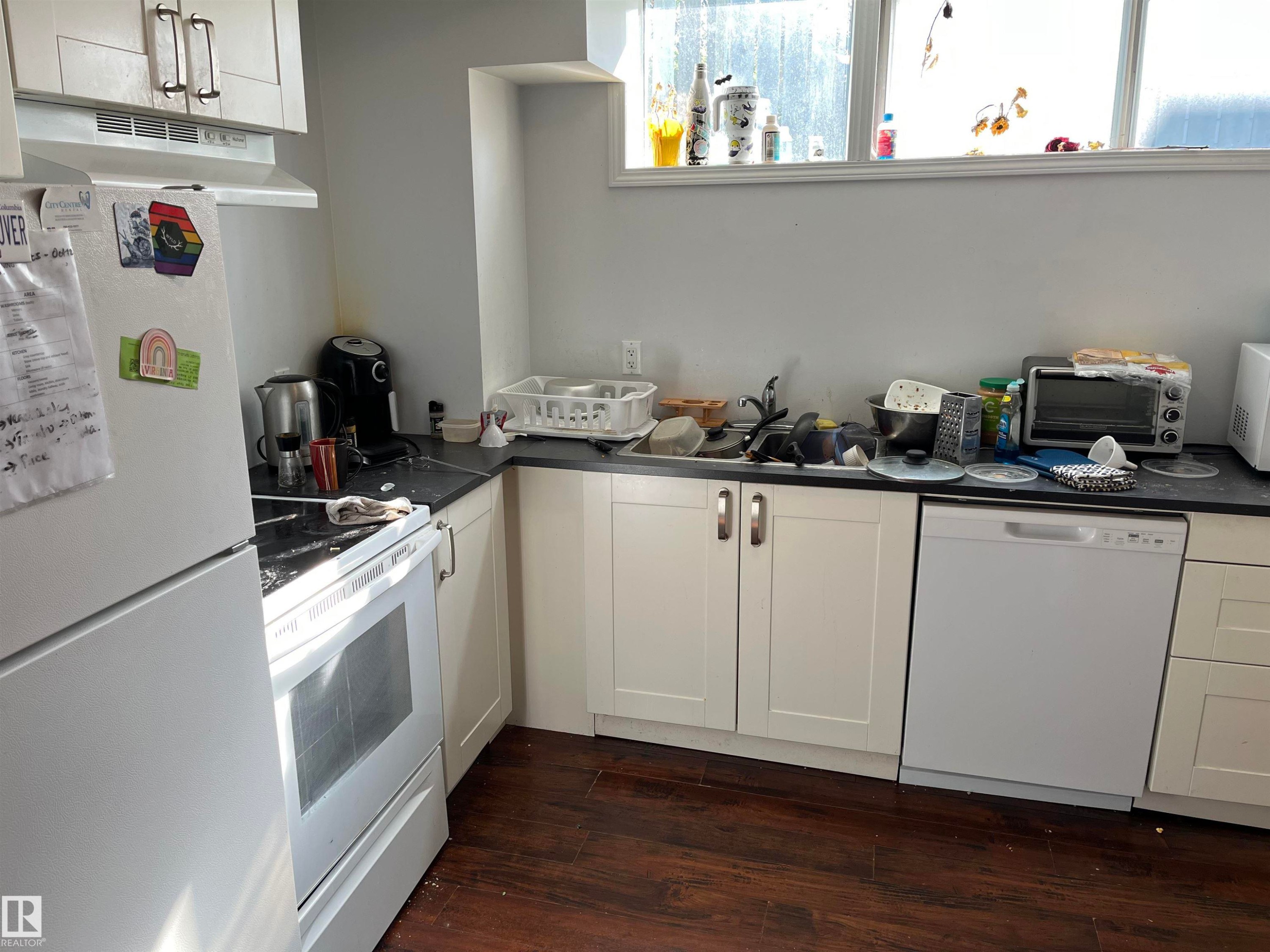 Efficient kitchen featuring white cabinetry, black countertops, and stainless steel appliances including a gas range and dishwasher - 12011 87 Avenue Nw, Edmonton, AB - Indoor Photo Showing Kitchen