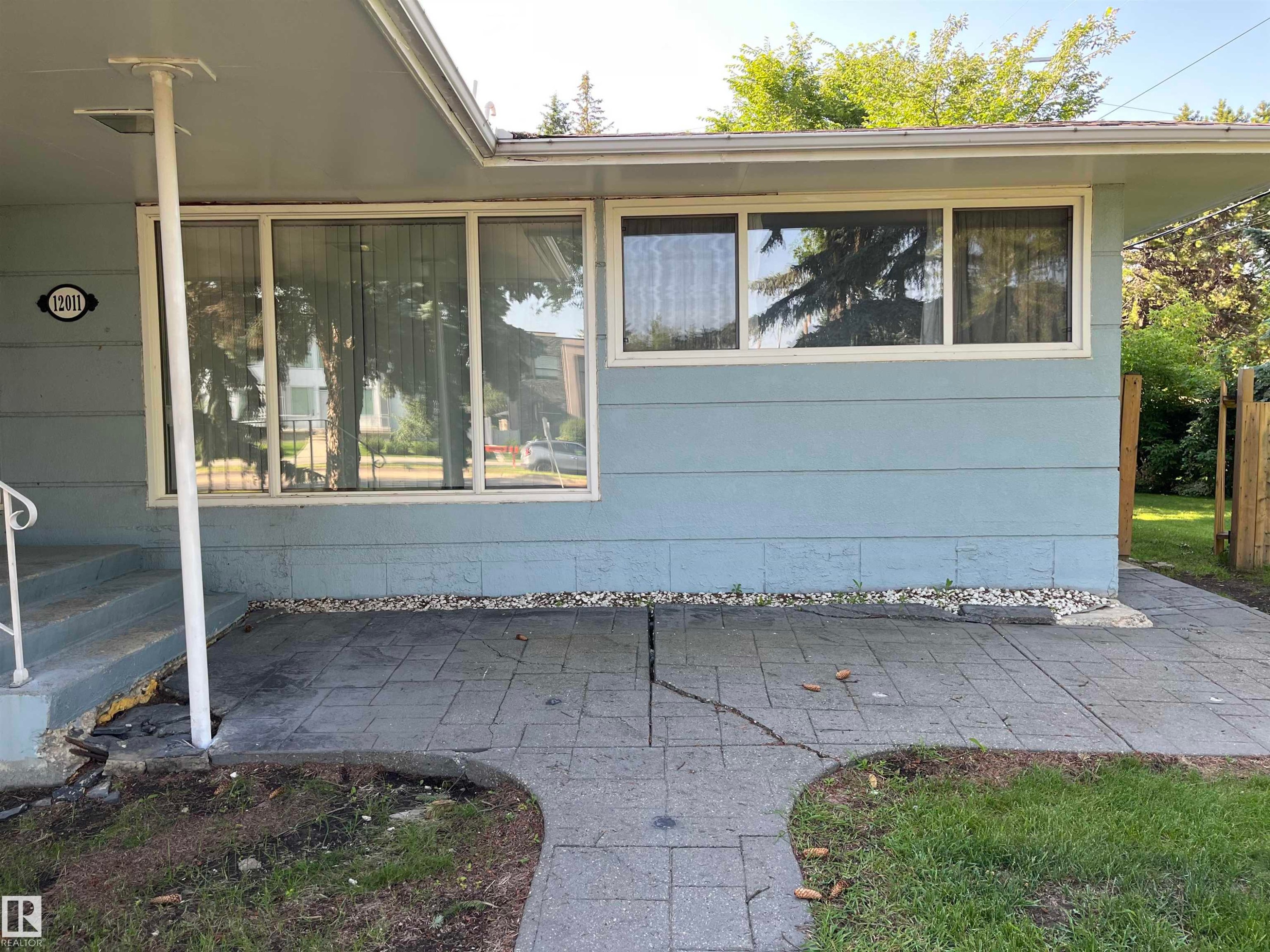 Covered patio featuring stamped concrete flooring with mature landscaping and privacy fencing - 12011 87 Avenue Nw, Edmonton, AB - Outdoor