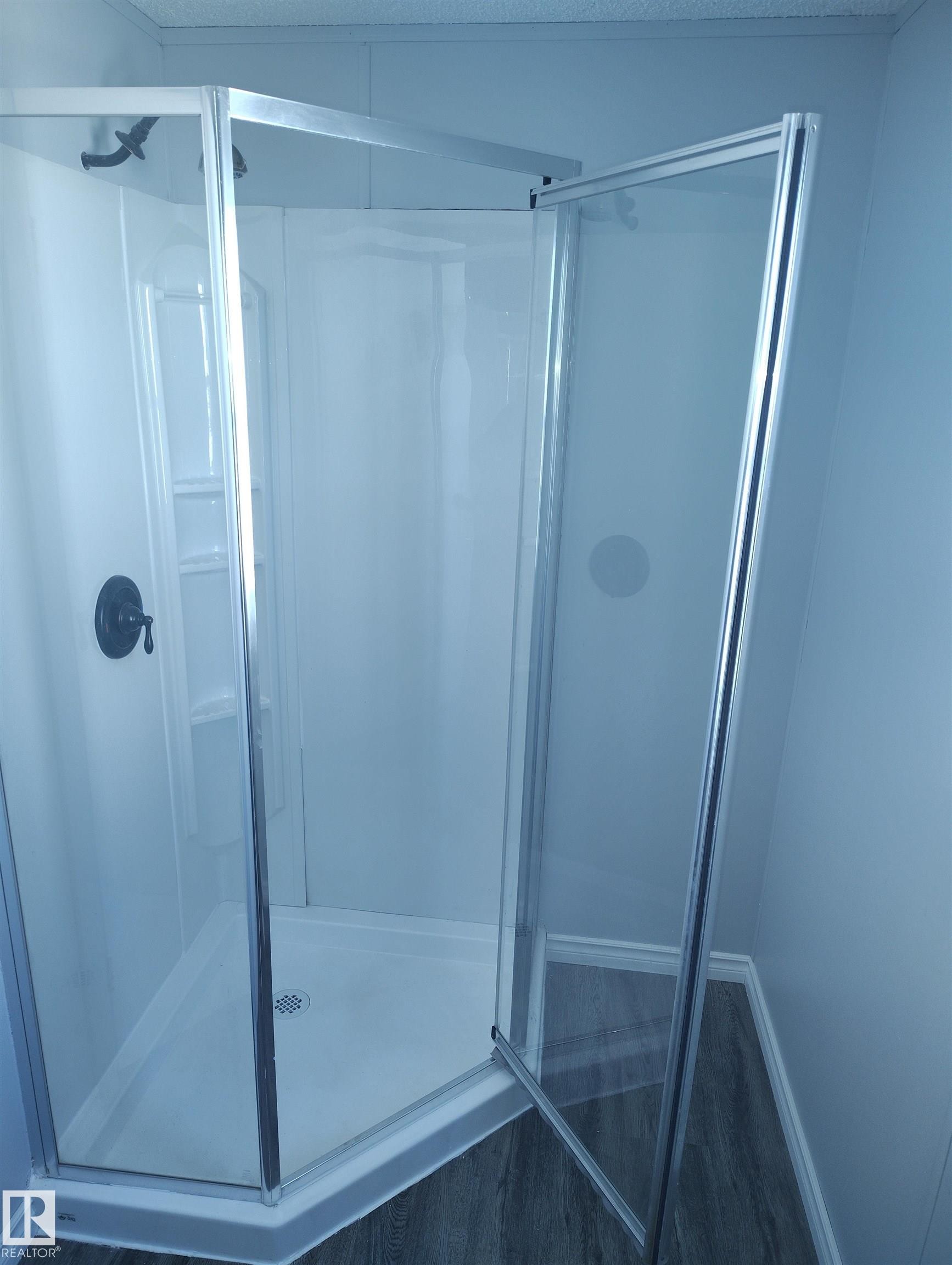 Corner shower enclosure with glass panels and chrome framing - 42 Midland Road, Millet, AB - Indoor Photo Showing Bathroom