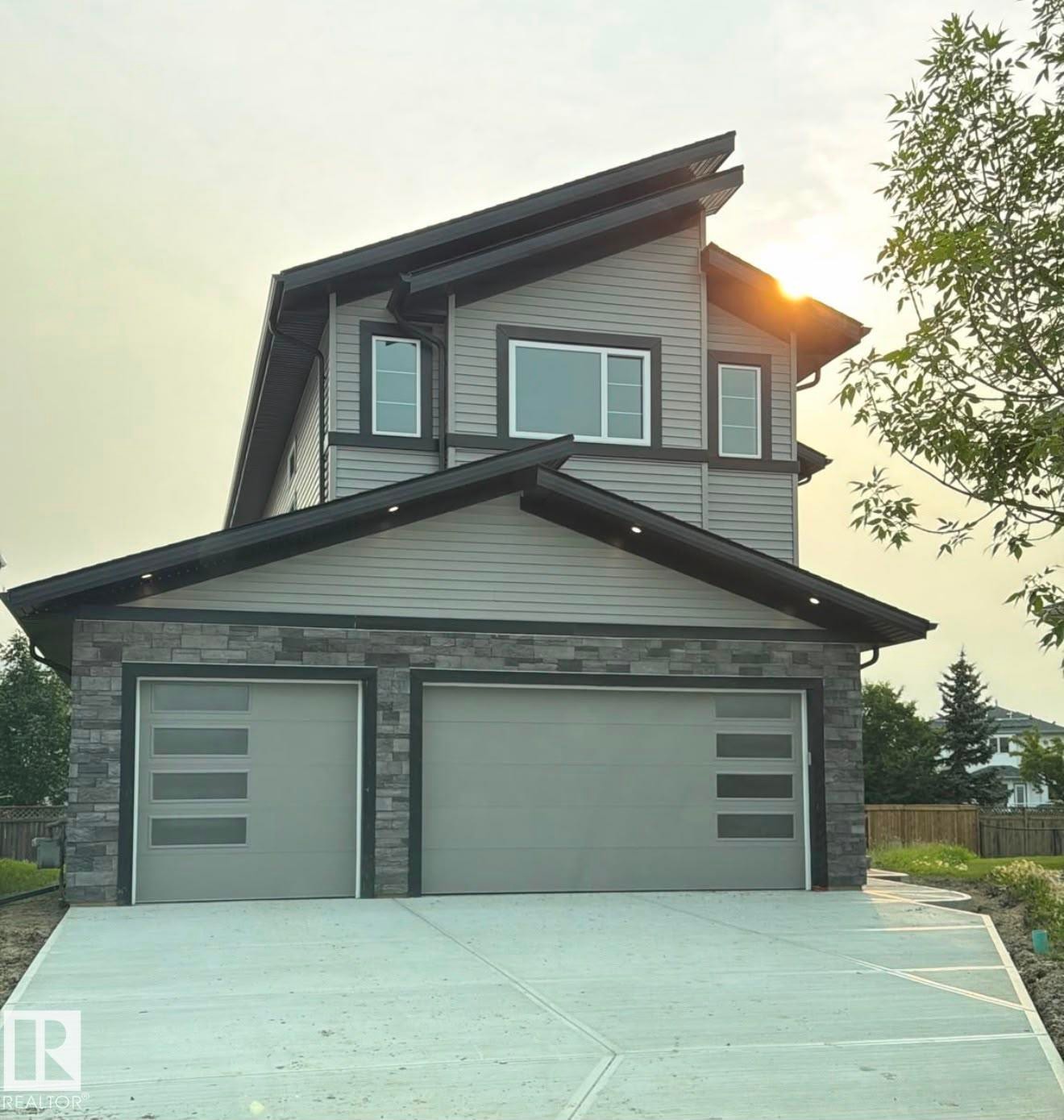 Contemporary two-story residence with a multi-pitched roofline and a concrete driveway - 34 Mckenzie Close Close, Leduc, AB - Outdoor With Exterior