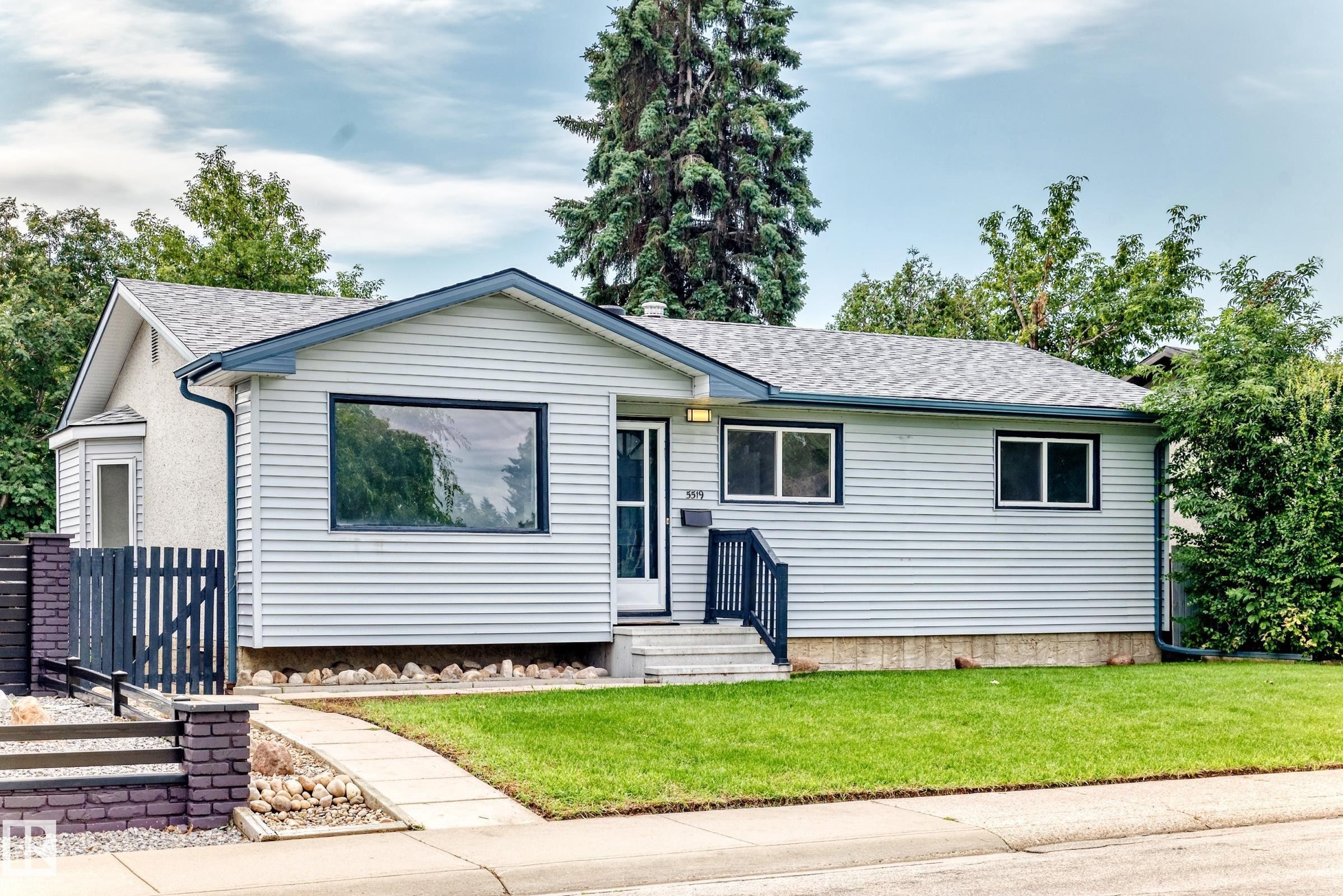 Light-colored siding exterior with a contrasting dark trim roofline - 5519 142 Avenue Nw, Edmonton, AB - Outdoor