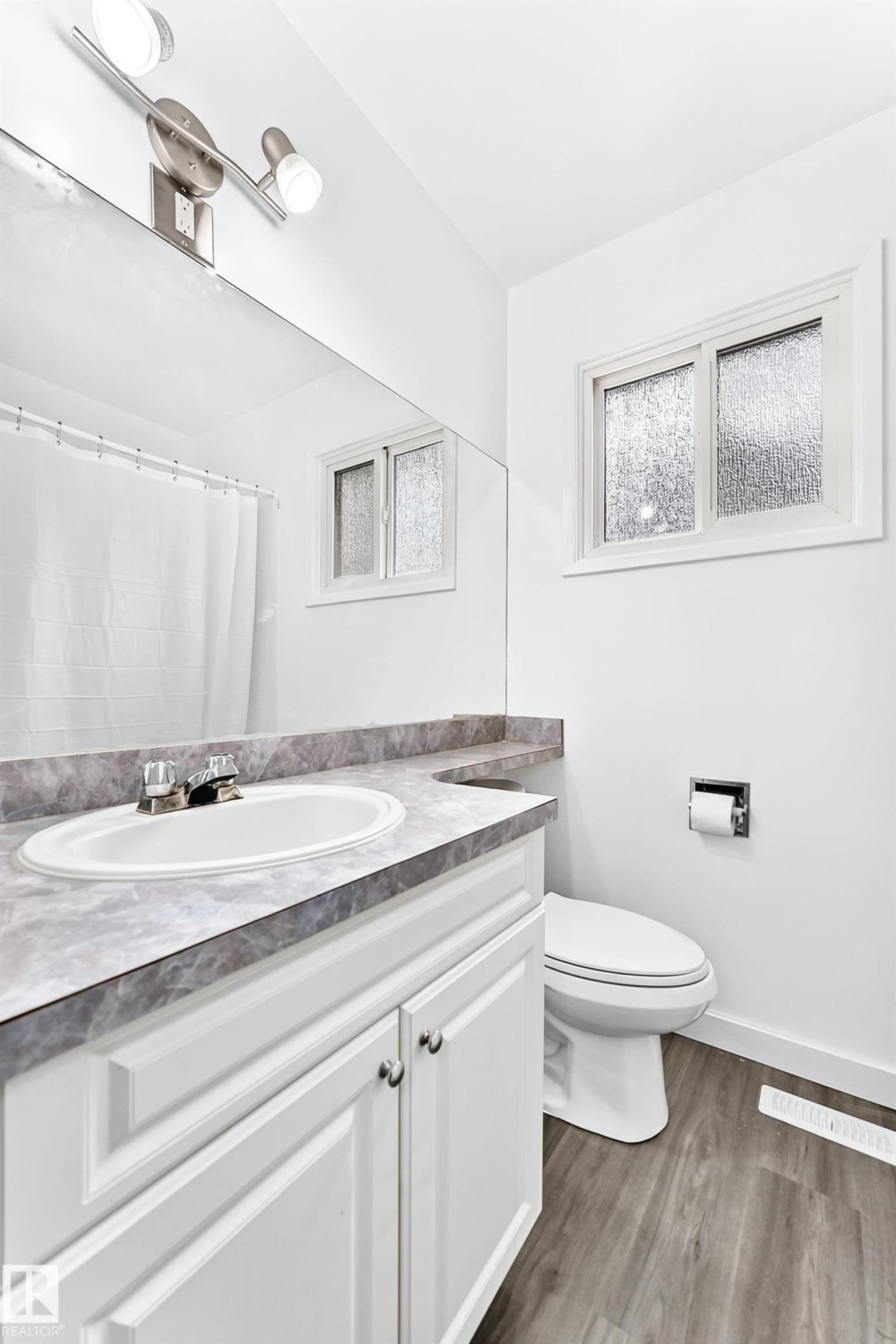 Bathroom featuring a vanity with an integrated sink and a marbled countertop - 5519 142 Avenue Nw, Edmonton, AB - Indoor Photo Showing Bathroom