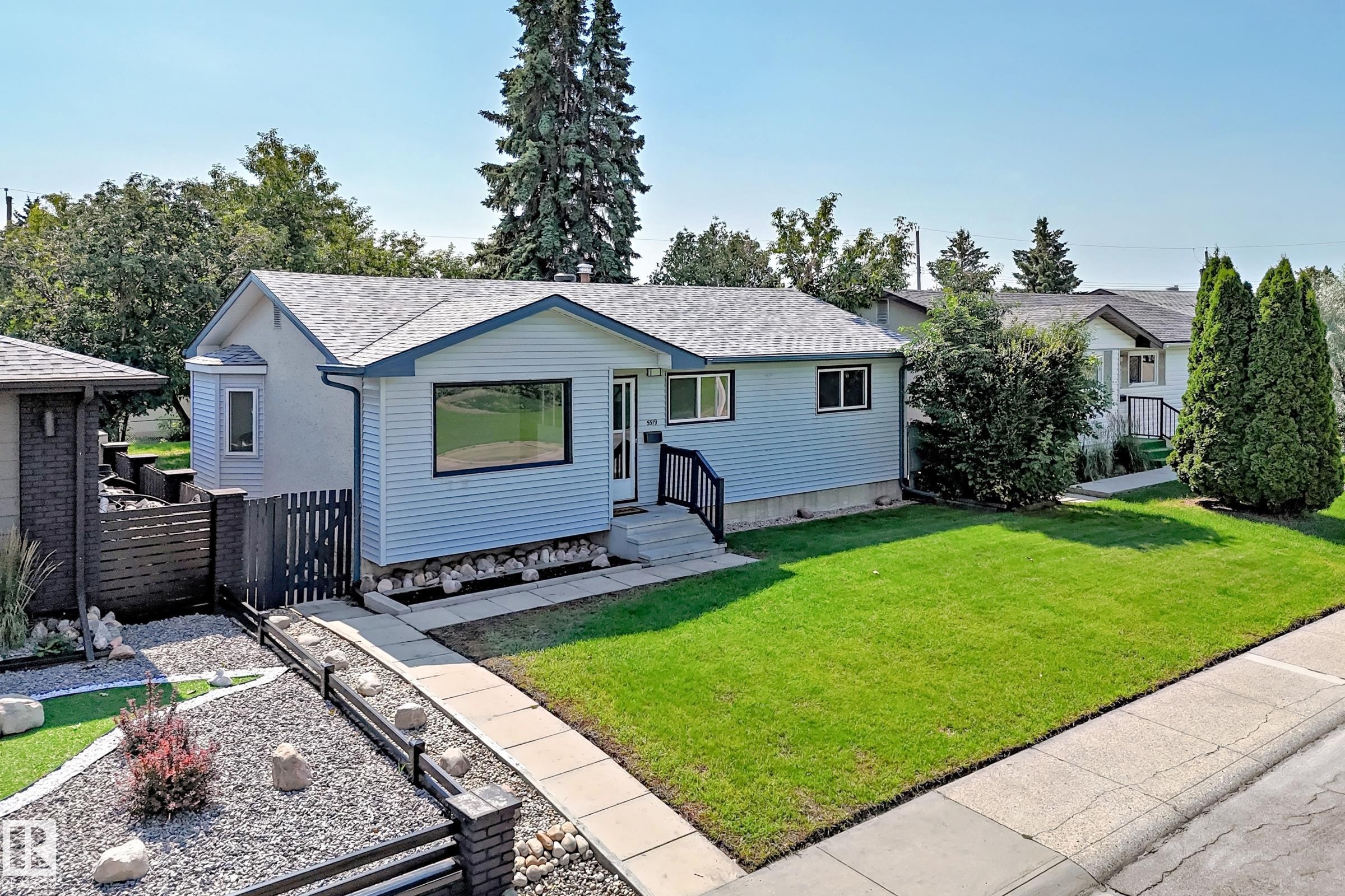 Light blue siding exterior featuring a contrasting dark trim roofline and bay window - 5519 142 Avenue Nw, Edmonton, AB - Outdoor