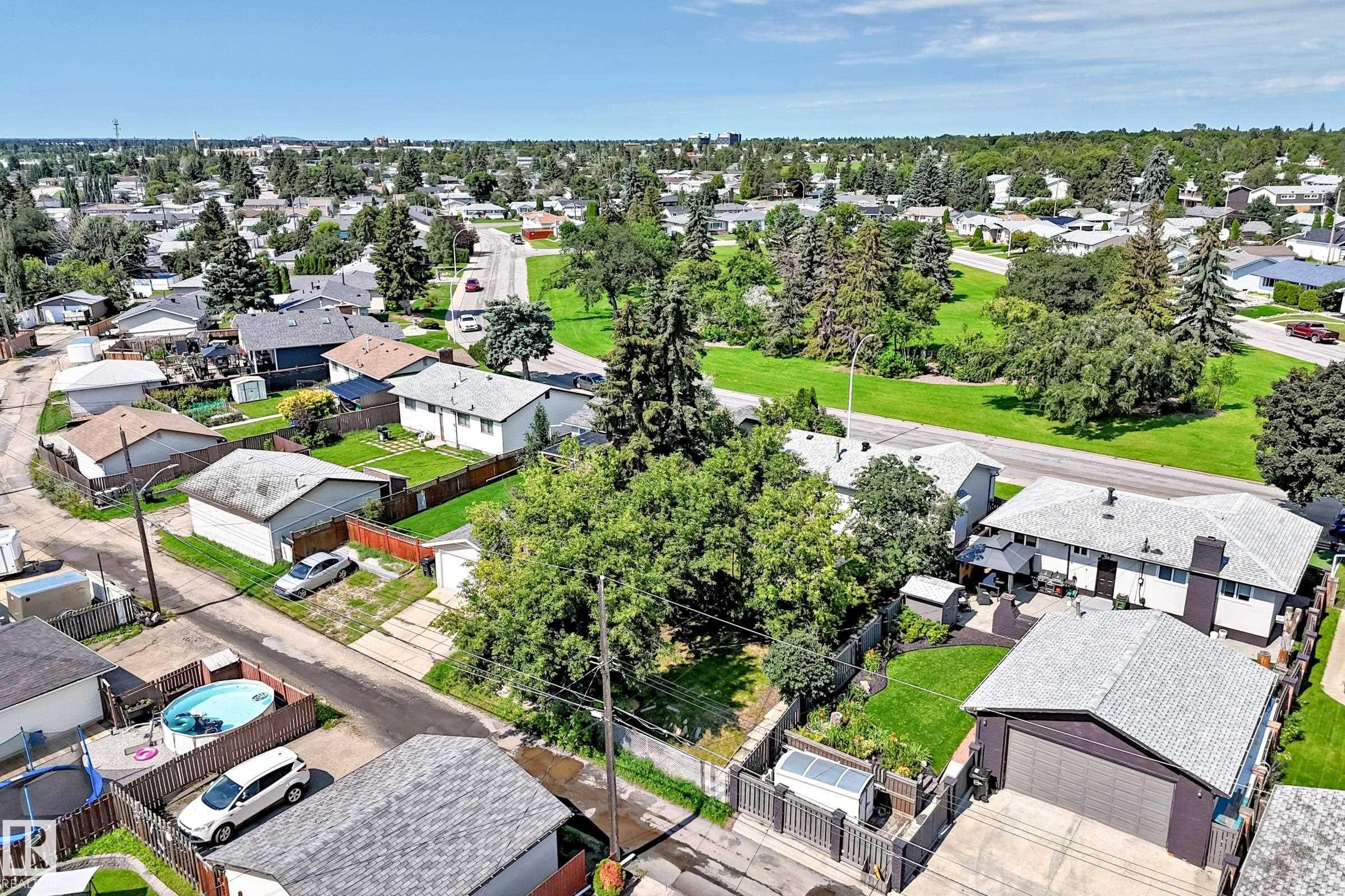 Aerial perspective showcasing a residential neighborhood with detached homes, mature trees, and green spaces - 5519 142 Avenue Nw, Edmonton, AB - Outdoor With Deck Patio Veranda