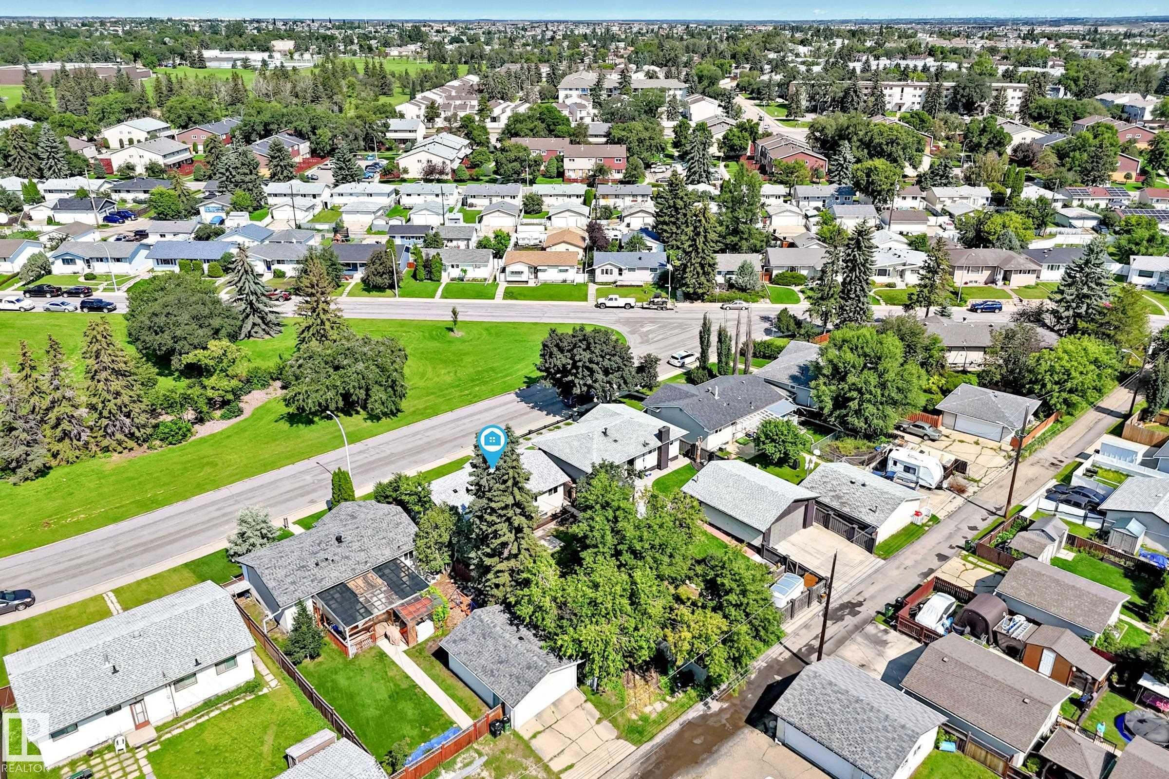 Aerial view showcasing a residential area with single-story homes, mature trees, and paved roads - 5519 142 Avenue Nw, Edmonton, AB - Outdoor With View