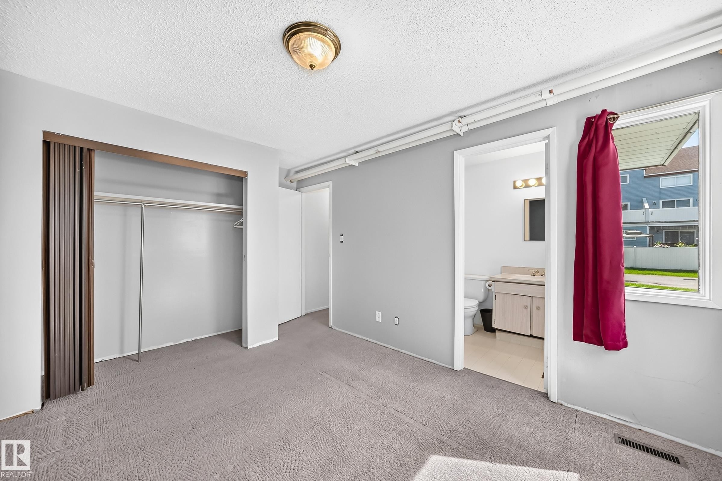 Carpeted room with a full closet featuring bi-fold doors - 290 Lancaster Terrace Nw, Edmonton, AB - Indoor