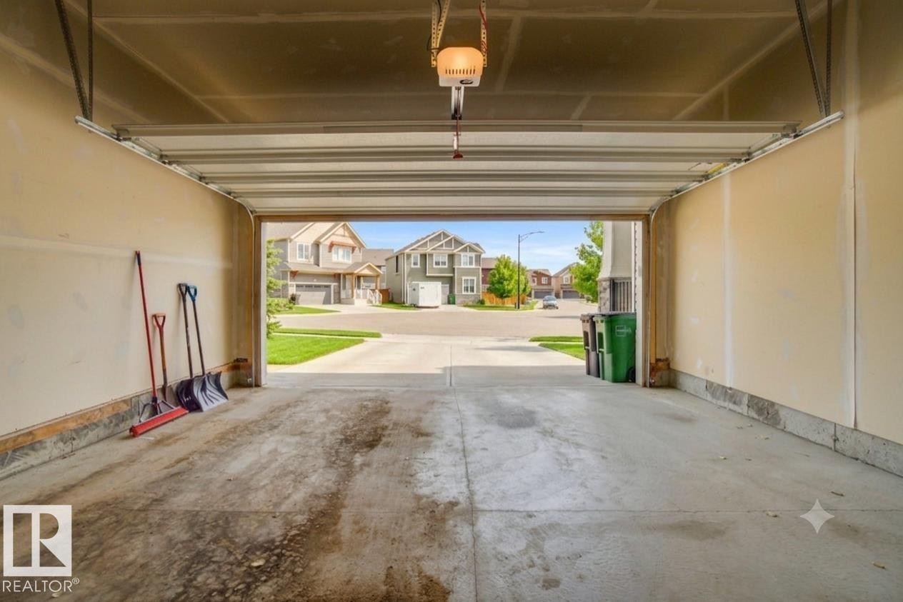 Spacious two-car garage with an automatic door opener and concrete flooring - 1607 202 Street Nw, Edmonton, AB - Indoor Photo Showing Garage