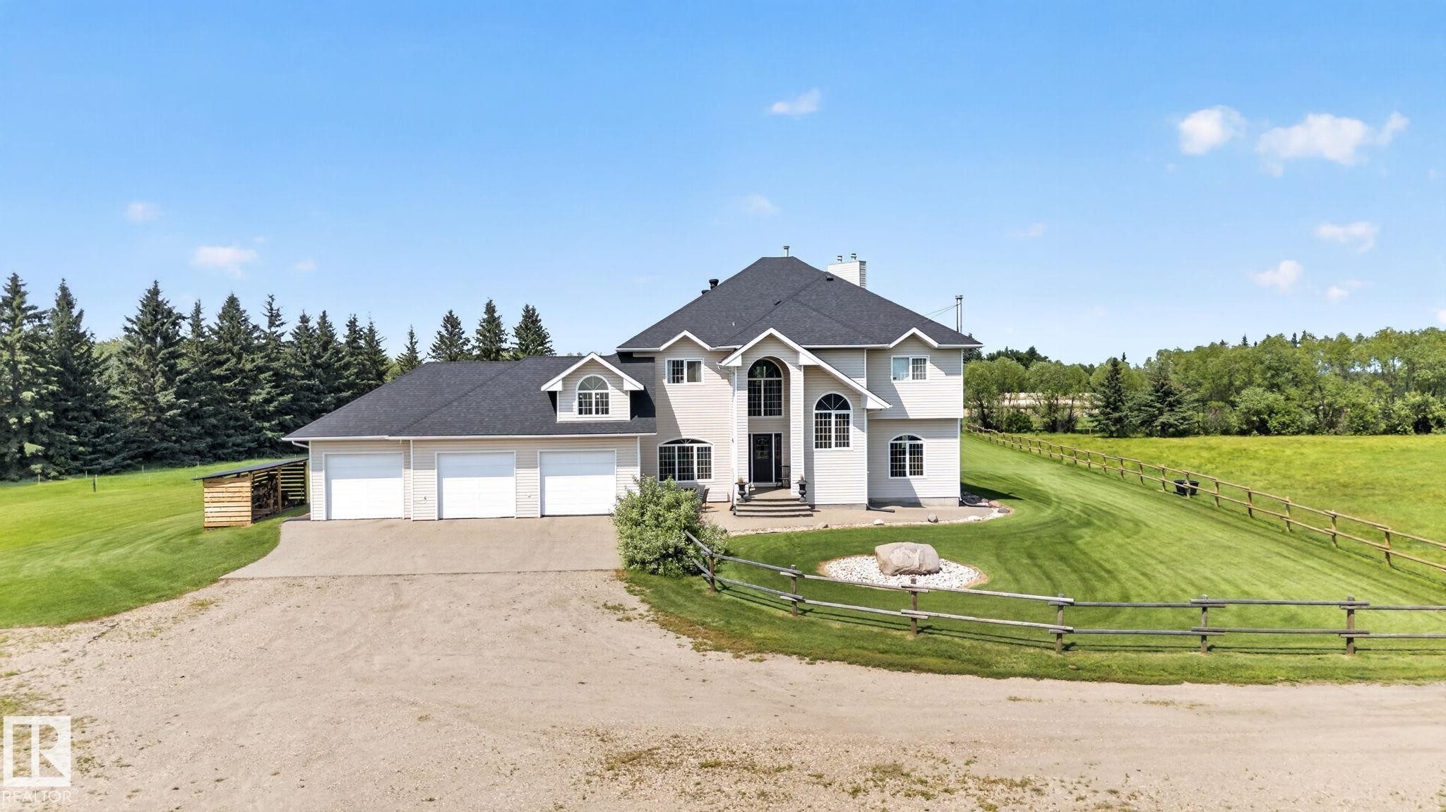 Spacious property featuring a light-toned exterior with multiple gables and a dark roof - 50336 Range Road 280, Rural Leduc County, AB - Outdoor