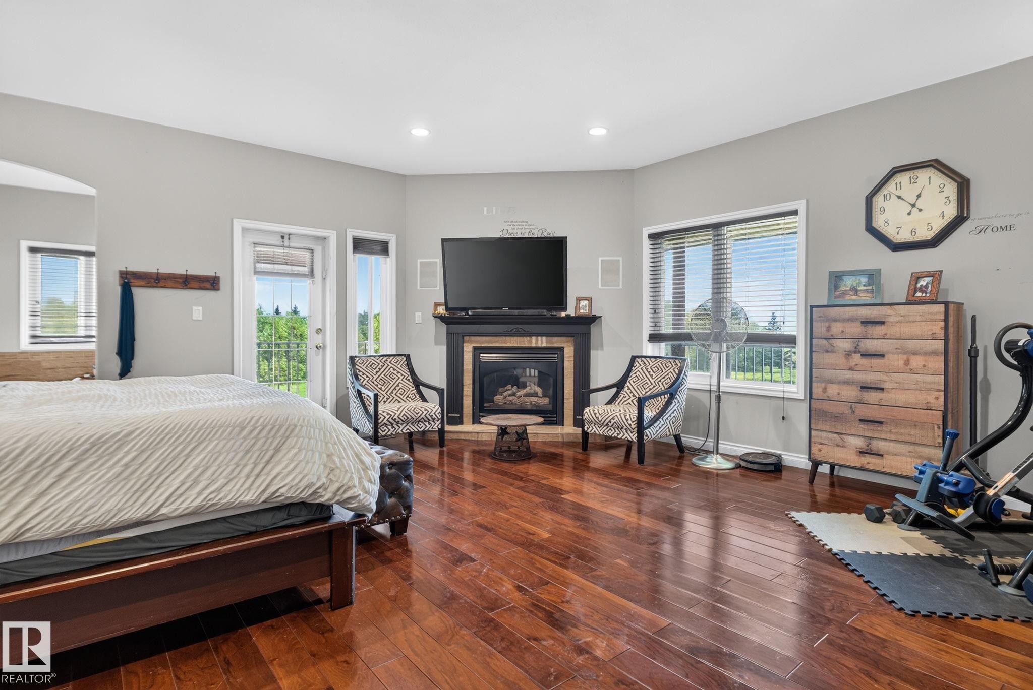 Wide plank wood-finish flooring complements the room's neutral wall tones - 50336 Range Road 280, Rural Leduc County, AB - Indoor Photo Showing Bedroom With Fireplace
